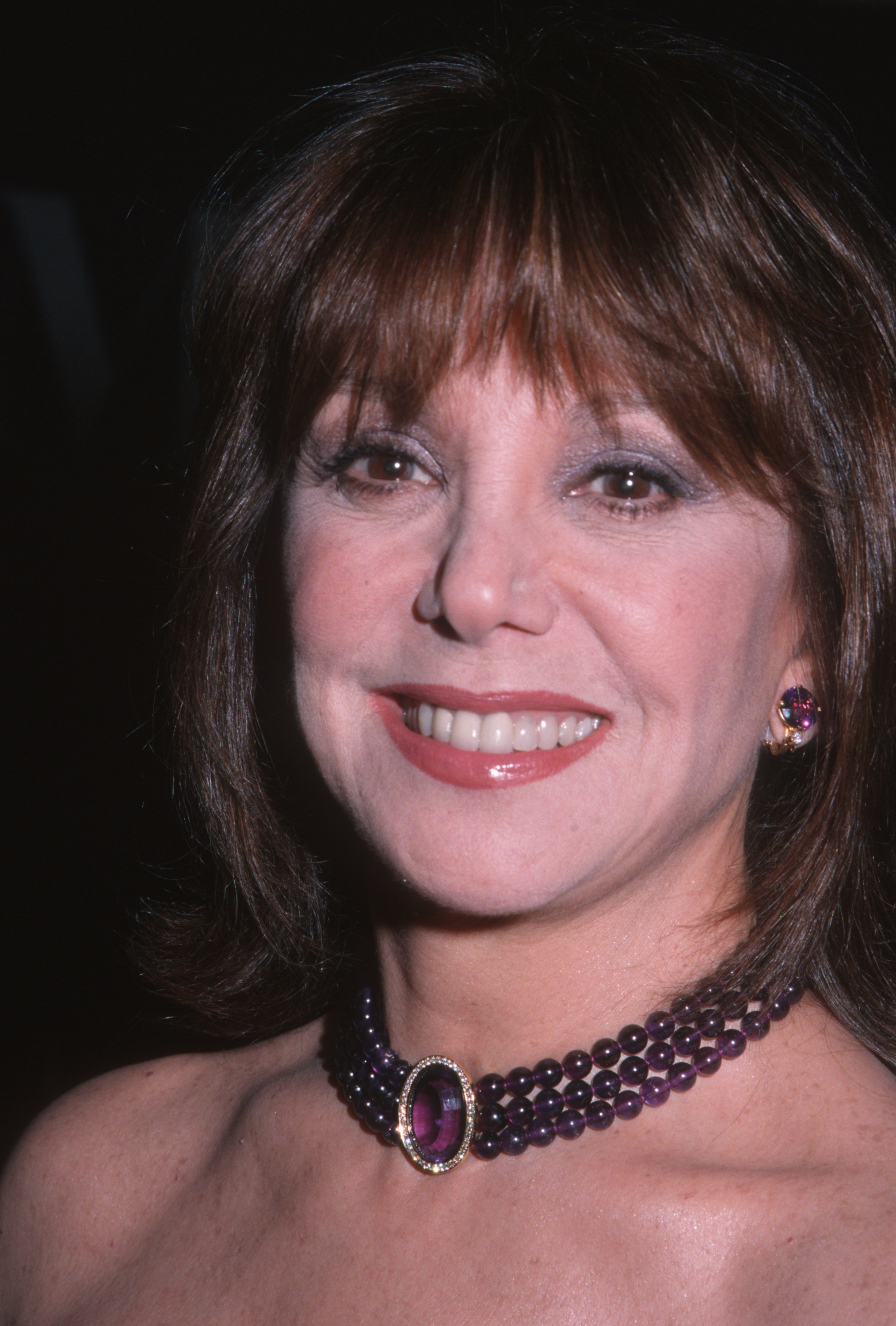 Marlo Thomas smiles at the Museum of Television and Radio Annual Gala honoring Sid Caesar, complementing her elegant look with a striking amethyst-toned necklace and matching earrings. | Source: Getty Images