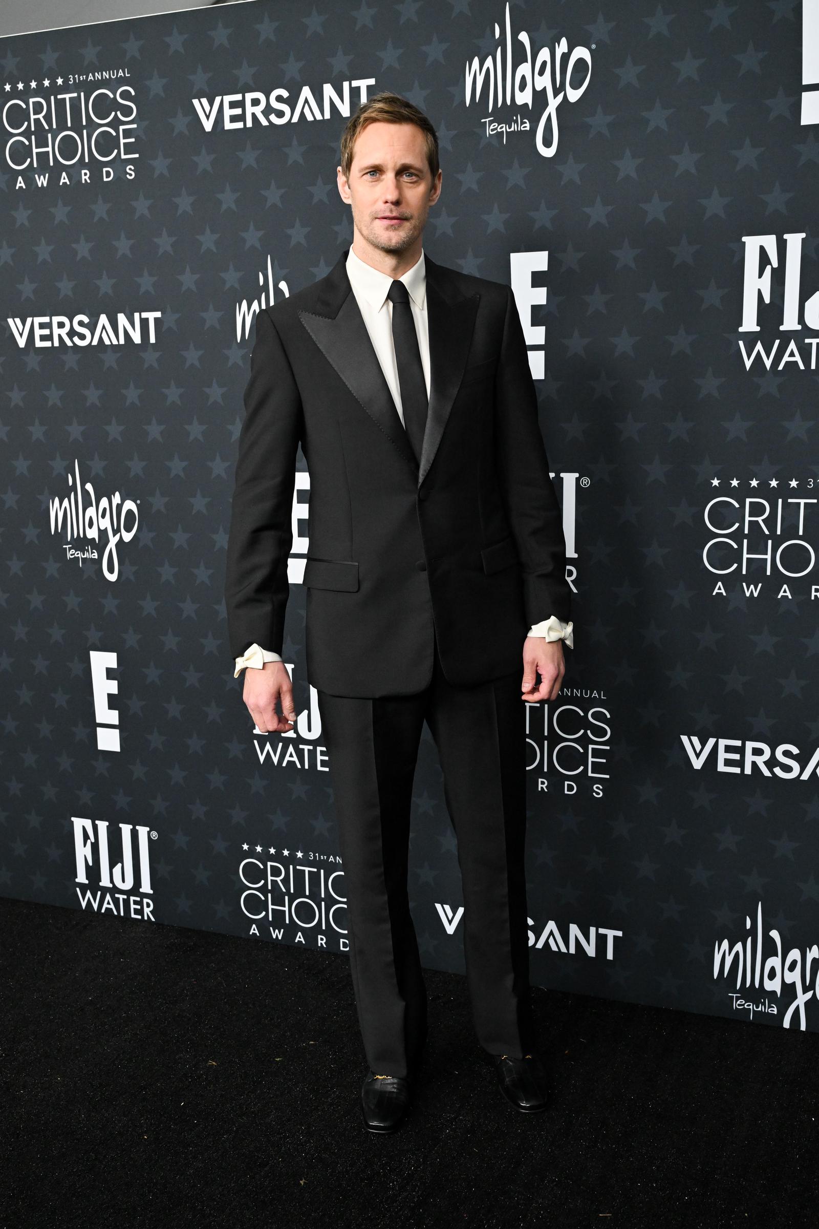 Alexander Skarsgård keeps it refined in a well-tailored black suit and tie, opting for a clean, traditional red carpet look | Source: Getty Images