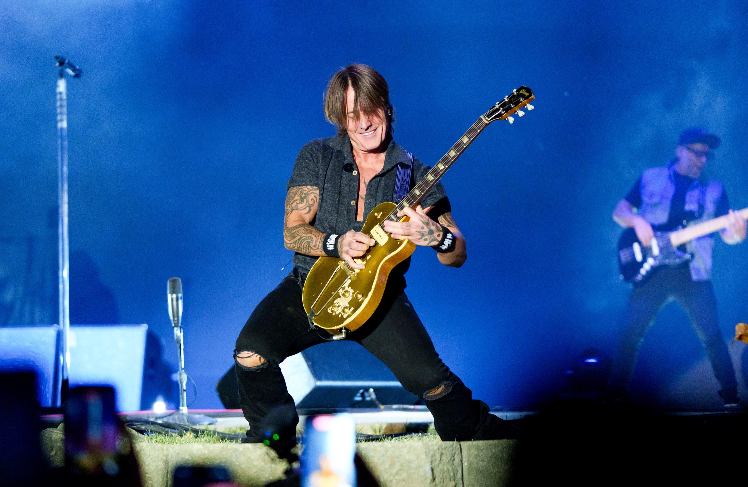 Keith Urban performs during a July 2026 concert, guitar in hand, as he works the stage for an enthusiastic crowd. The singer would later become emotional during his Atlantic City show after performing “We Go Back.” | Source: Getty Images