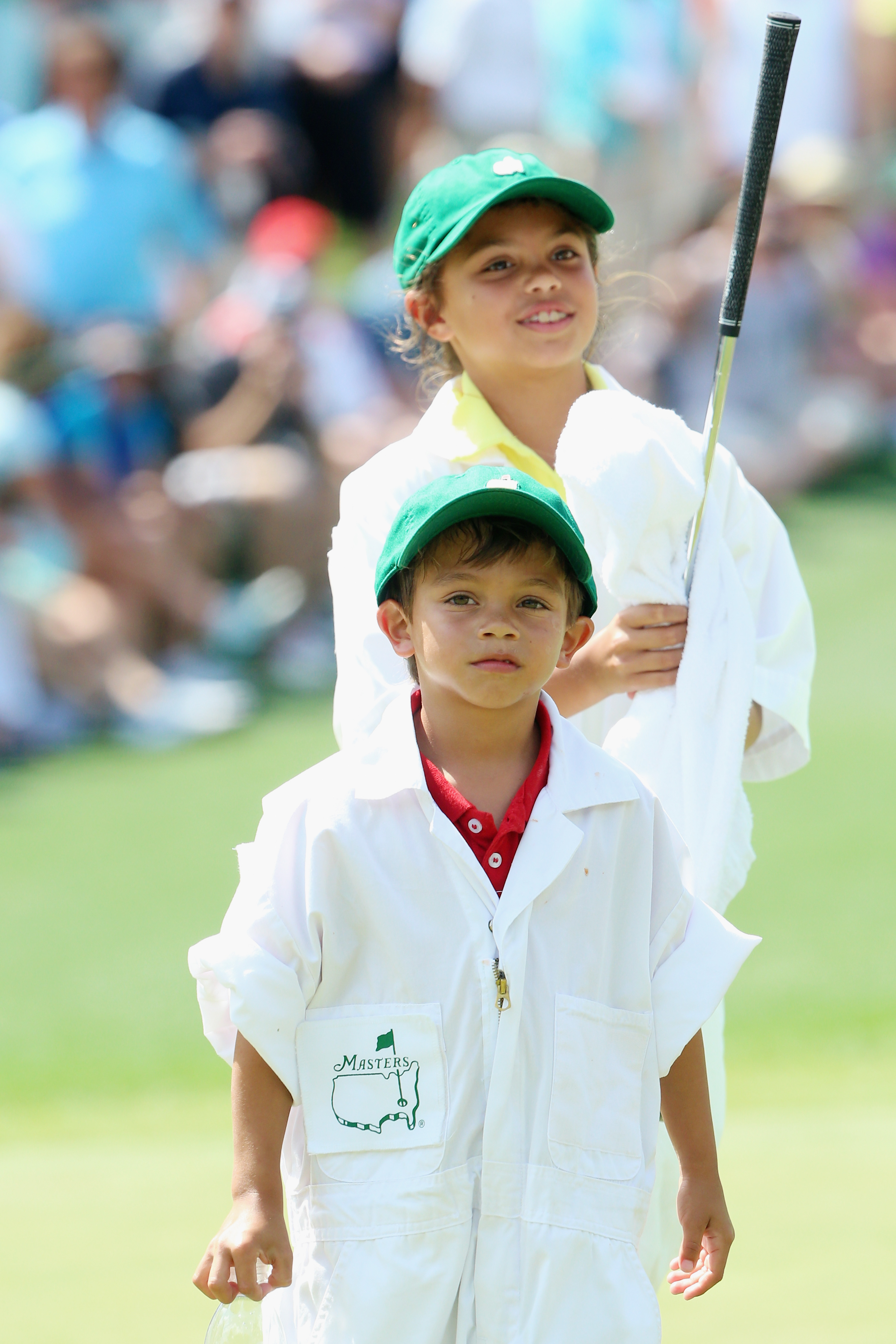 Charlie Woods and Sam Woods work as caddies for Tiger Woods during the Par 3 Contest prior to the start of the Masters Tournament at Augusta National Golf Club on April 8, 2015, in Augusta, Georgia | Source: Getty Images