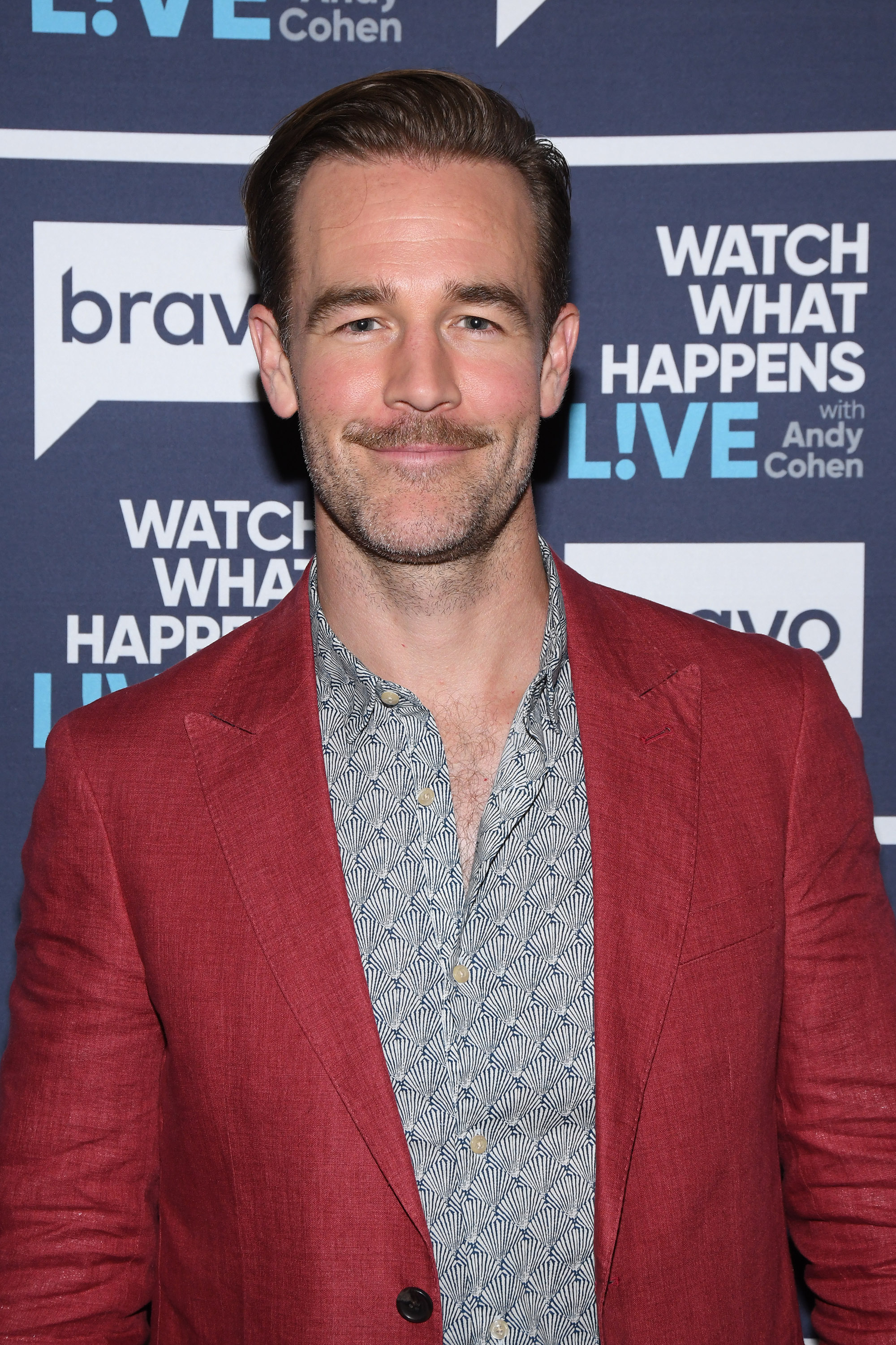 James Van Der Beek brings effortless charm to the "Watch What Happens Live" set in a bold red jacket and patterned shirt. His neat mustache adds retro-cool flair as he smiles easily, ready for a fun night on Andy Cohen's couch.