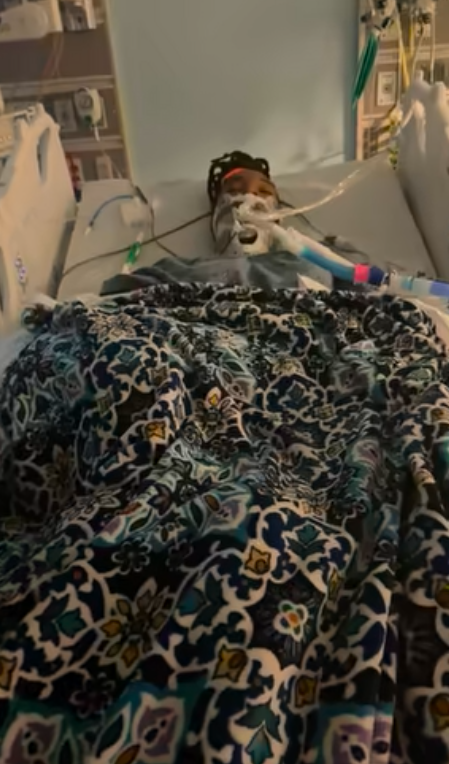 Jada West laying unconscious in a hospital bed. | Source: Facebook/De'Quala McClendon