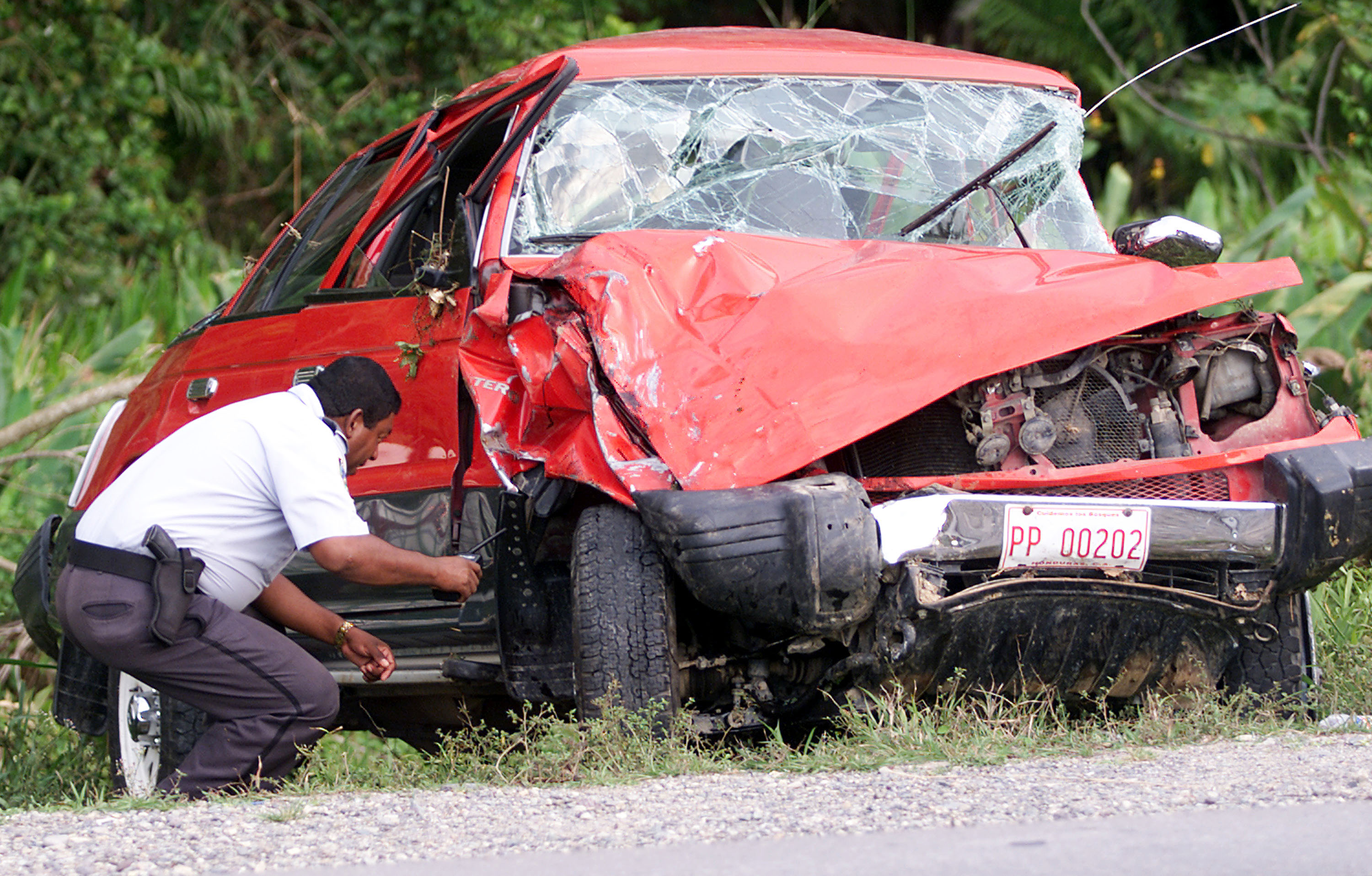 A Honduran policeman inspects the vehicle driven by Lisa Lopes on April 27, 2002 | Source: Getty Images