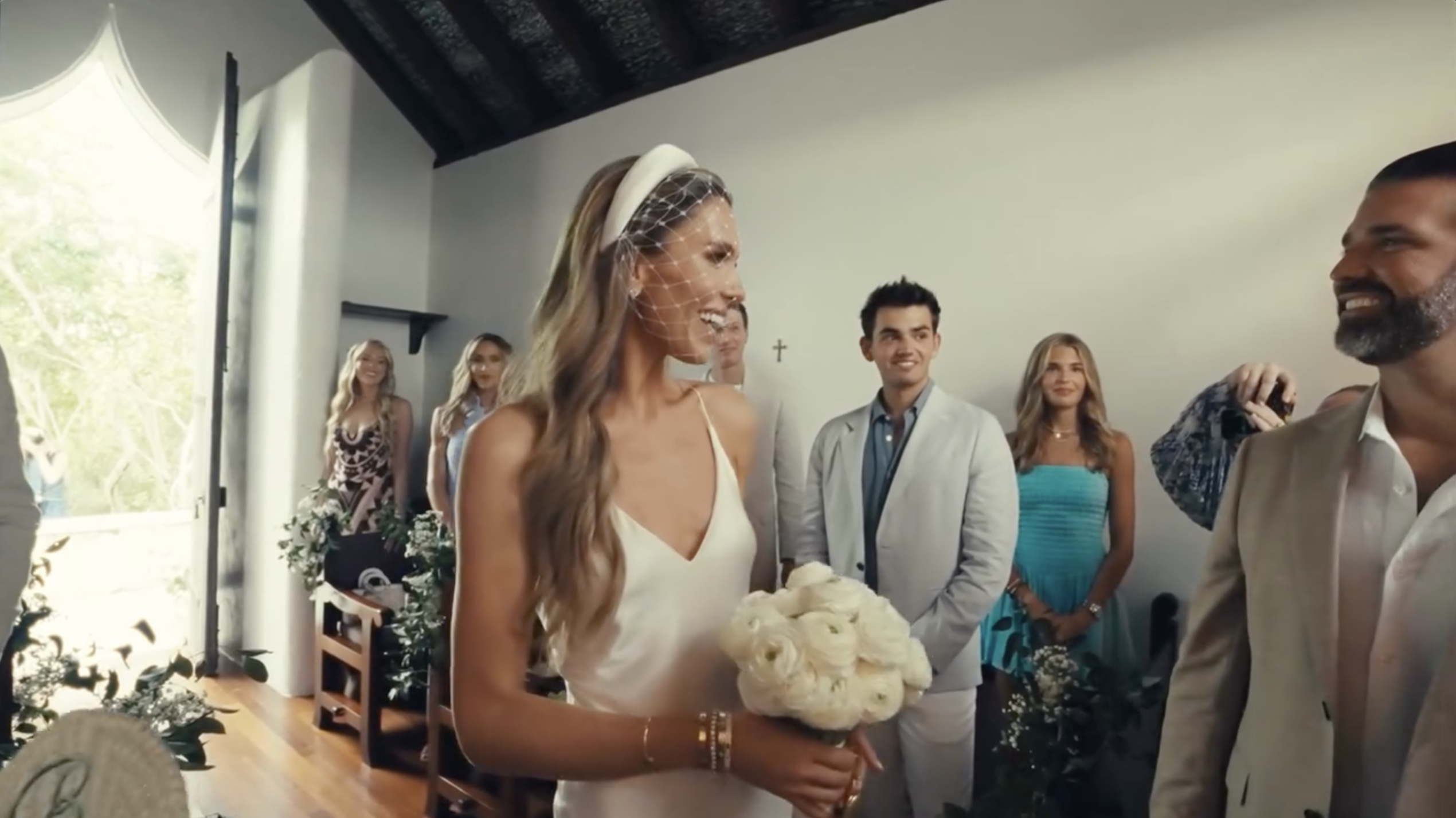 Bettina Anderson smiles as she approaches Donald Trump Jr. inside the chapel, bouquet in hand and guests looking on. | Source: Instagram/donaldjtrumpjr