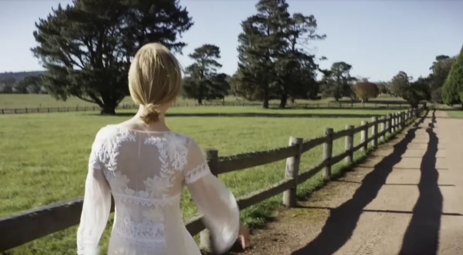 A tree-lined path and split-rail fence stretch into the distance, framing the sweeping landscape where manicured grounds blend with native greenery. From a video dated July 20, 2015. | Source: YouTube/Vogue