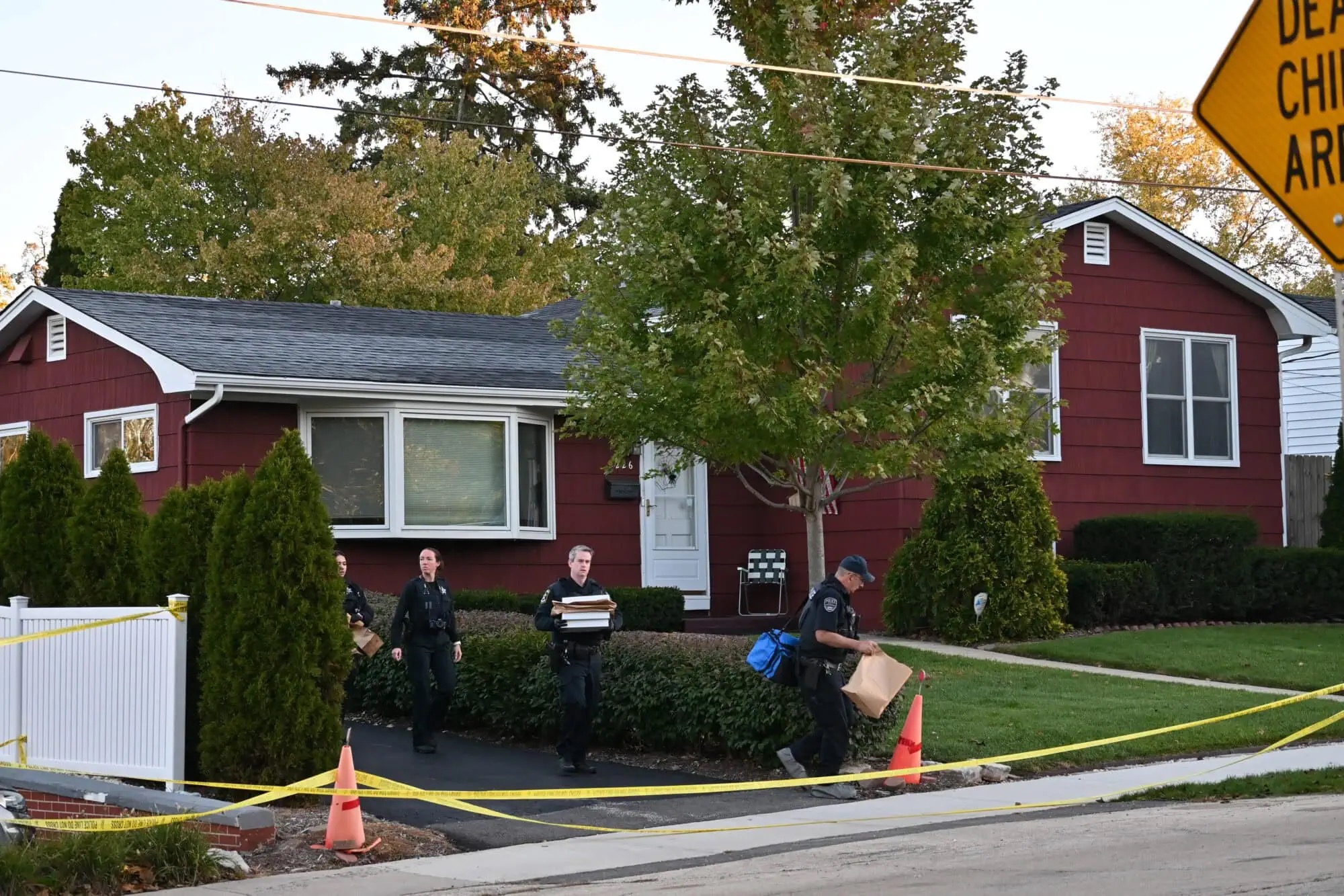 Investigators carry evidence bags and boxes from the Schmidt family property as multiple law enforcement agencies work to piece together what happened inside the home. | Source: Nick Rusin / Lake & McHenry County Scanner.