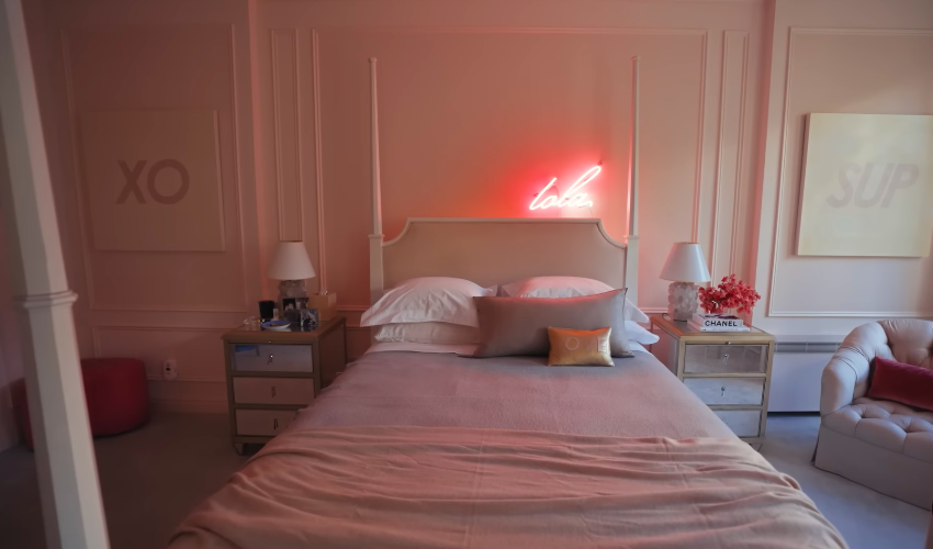 Lola's bedroom brings a soft, youthful contrast to the rest of the home. The pink palette and neon sign make it feel unmistakably personal. | Source: YouTube/Architectural Digest