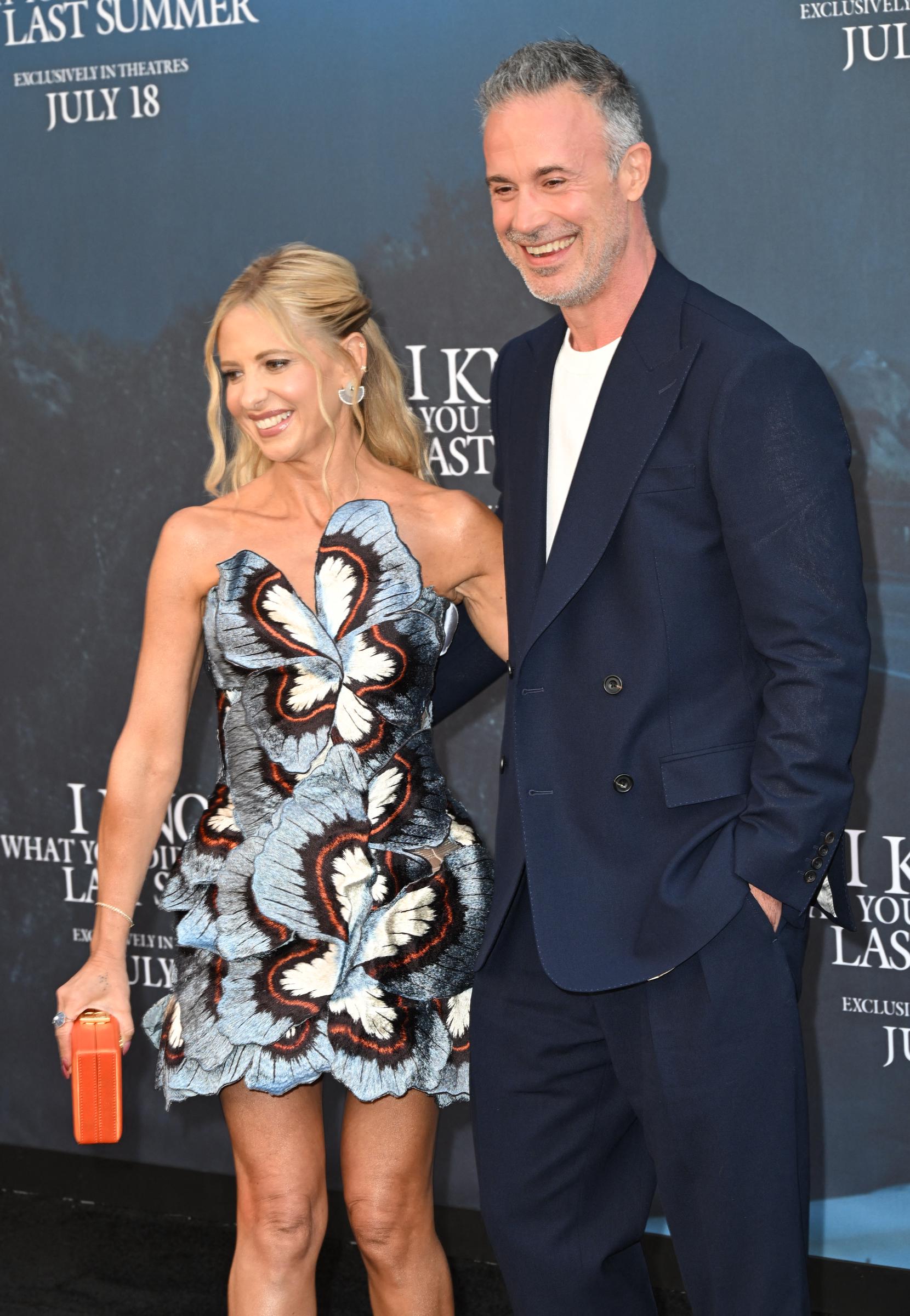 Gellar and Prinze Jr. share a laugh, with her smiling downward and him grinning off to the side. They appear to be parting ways after wrapping up their time posing together.