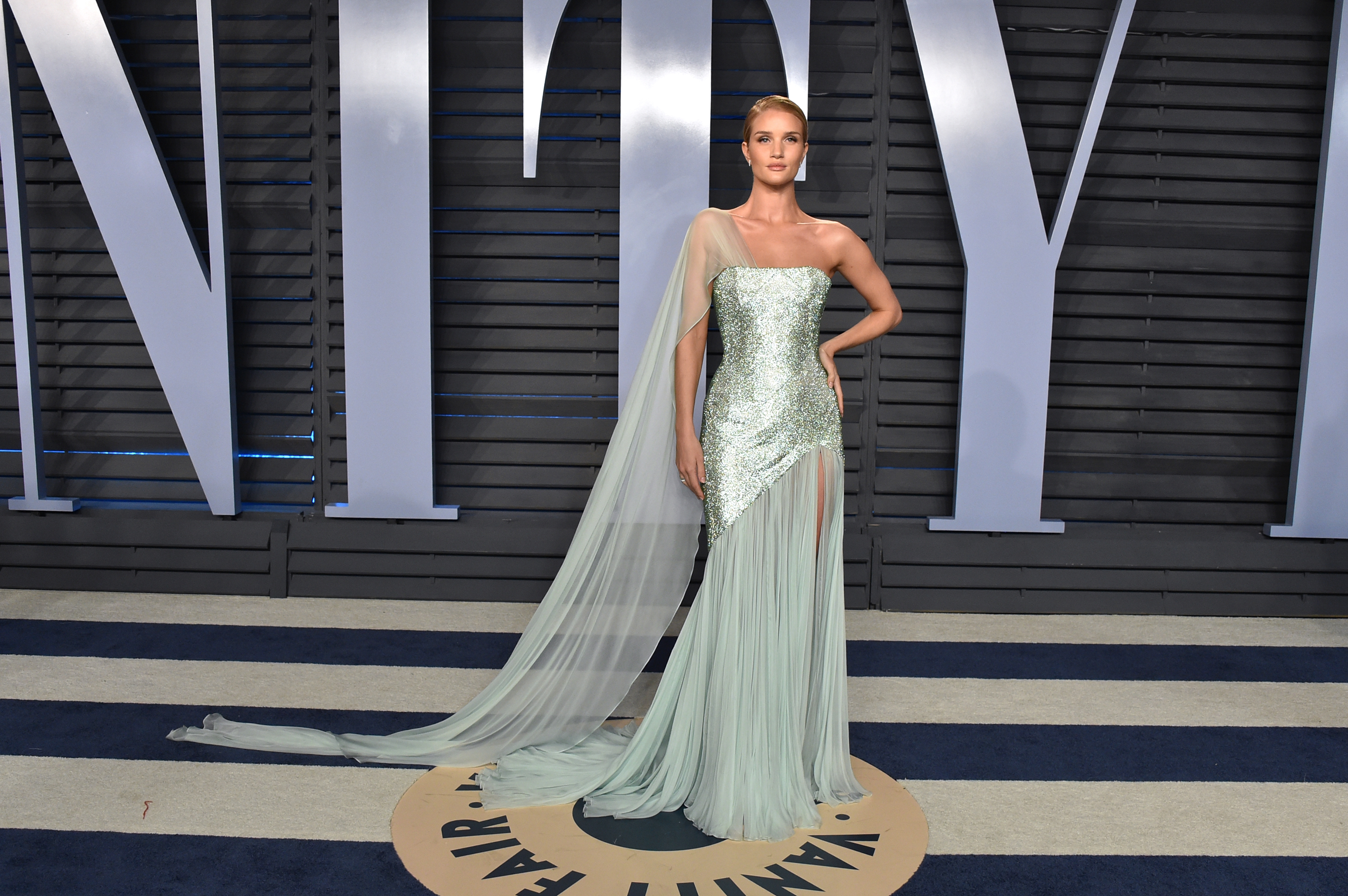 Rosie Huntington-Whiteley floats onto the Vanity Fair Oscar Party carpet in ethereal mint, one-shoulder sparkle, cascading chiffon, and pure goddess energy. | Source: Getty Images