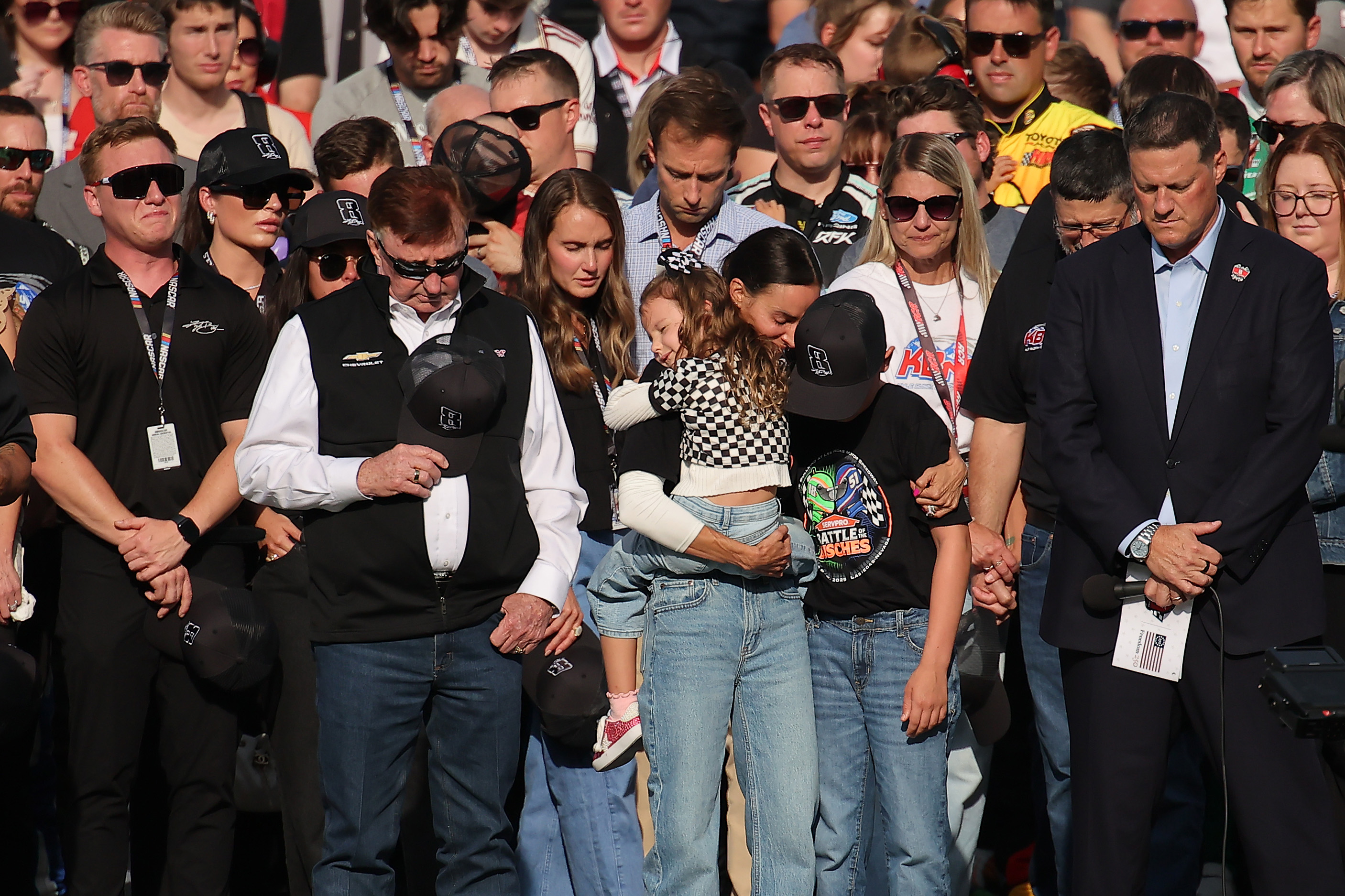 Hall of Famer and RCR team owner, Richard Childress, Samantha, Lennix, and Brexton Busch, and NASCAR Chief Executive Officer Steve O'Donnell stand on the grid during the remembrance ceremony for Kyle Busch at Charlotte Motor Speedway on May 24, 2026 | Source: Getty Images