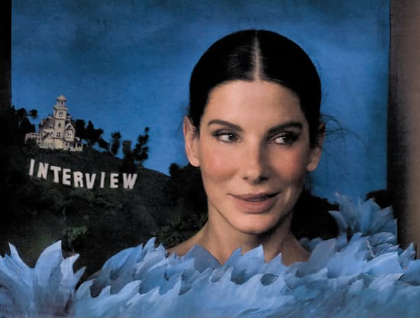 Sandra Bullock struck a playful close-up pose in a dramatic blue feathered look against a whimsical backdrop for her Interview Magazine feature. | Source: Instagram/sandrabullock
