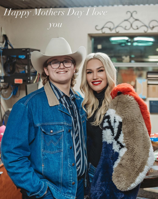 Zuma Rossdale sported a full western aesthetic in a denim jacket, striped button-down shirt, glasses, and a light-colored cowboy hat as he posed alongside his mother, Gwen Stefani. In this photo, they celebrated Mother's Day together in an image shared on May 11, 2025. | Source: Instagram/zuma_rossdalemusic