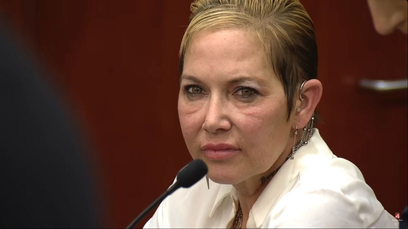 Scott's recent appearance offered a closer look at the 51-year-old as she sat before a courtroom microphone, wearing subtle makeup, layered necklaces, and several pieces of jewelry along her ear. Her closely cropped, side-swept blonde hairstyle became a particular focus online, with one netizen remarking that she "looks more like Slim Shady than Eminem does." | Source: YouTube/Click On Detroit | Local 4 | WDIV