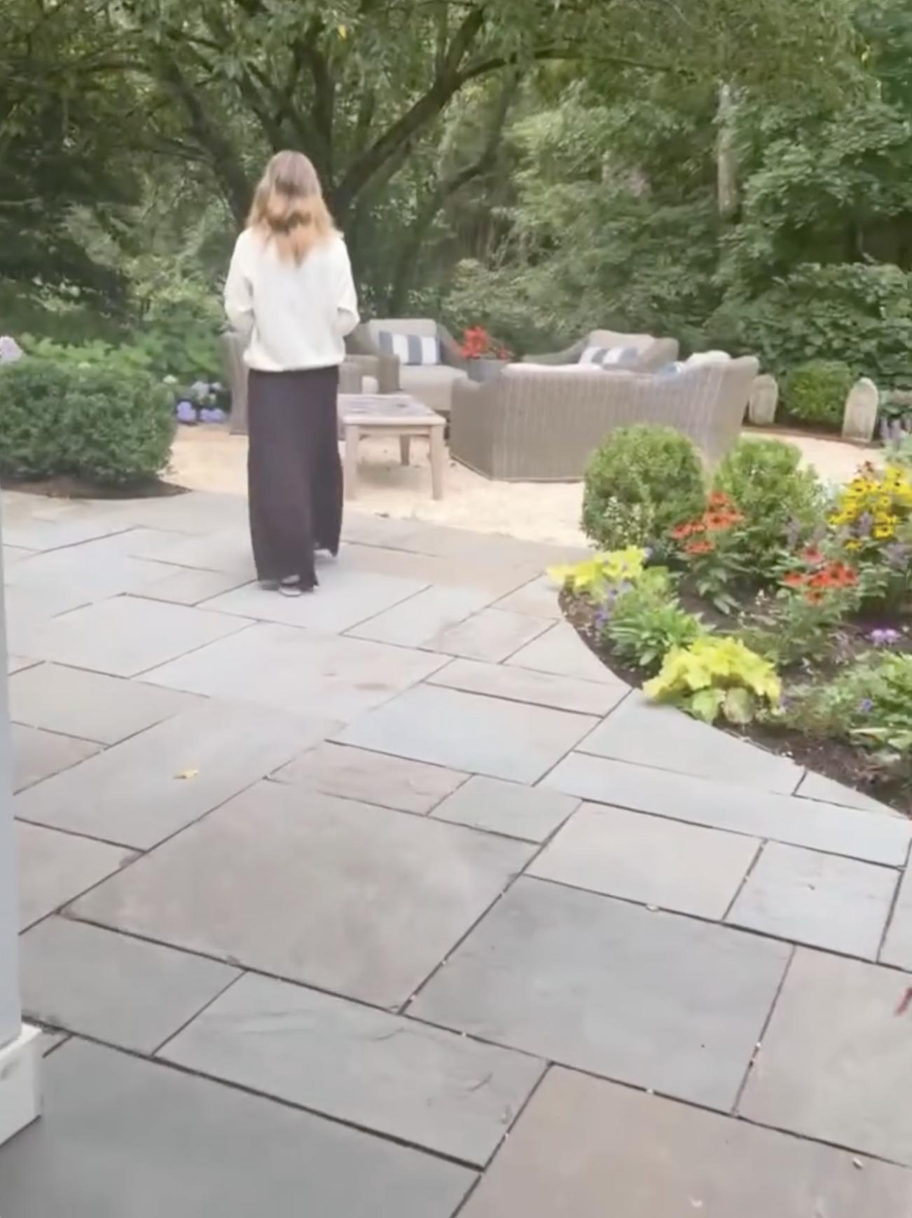 A patio lounge surrounded by mature trees, colorful flower beds, and landscaped greenery offers a quiet outdoor retreat on the property. | Source: Instagram/alejandragere