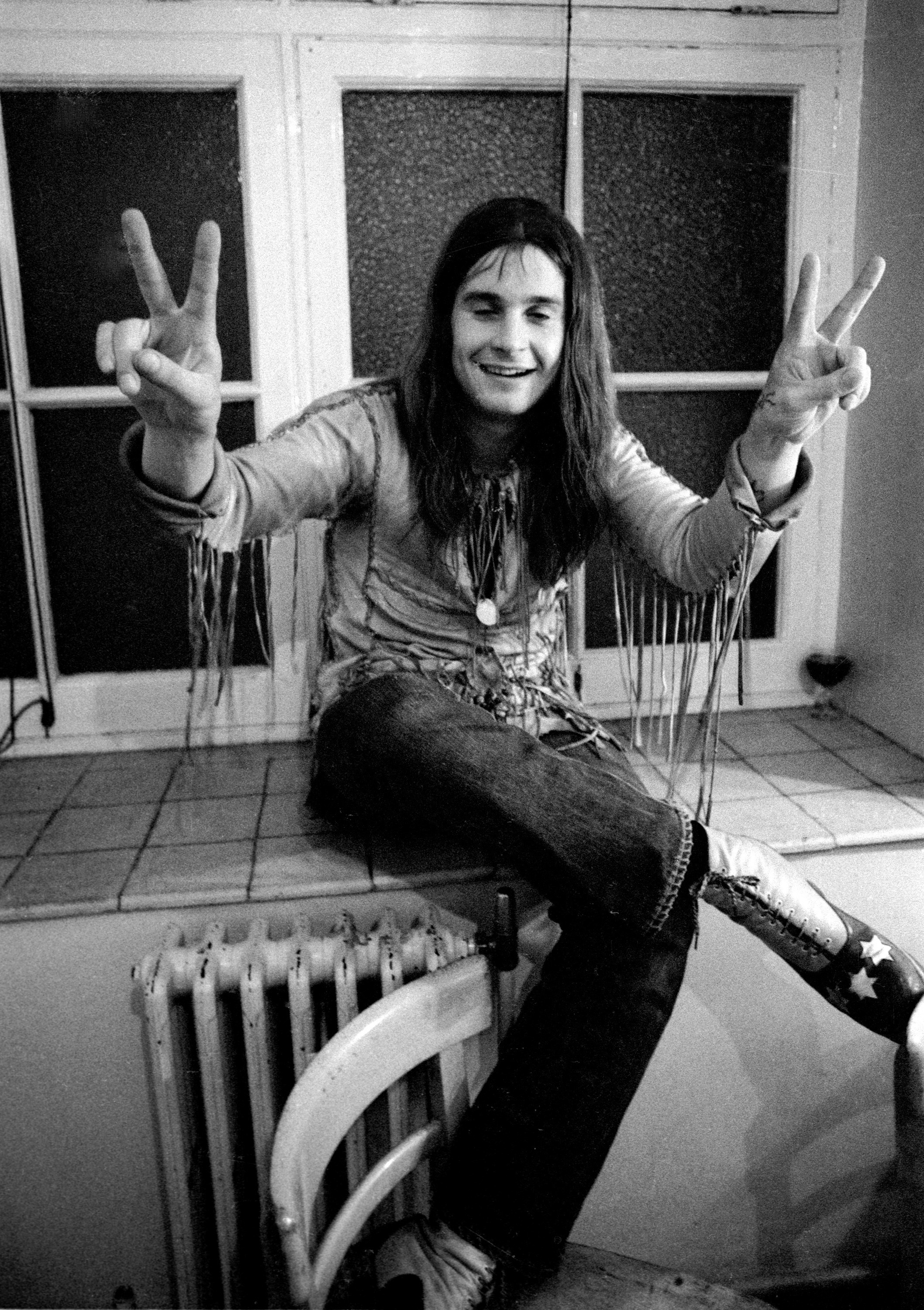 Ozzy Osbourne flashing the peace sign with both hands c. 1971. | Source: Getty Images