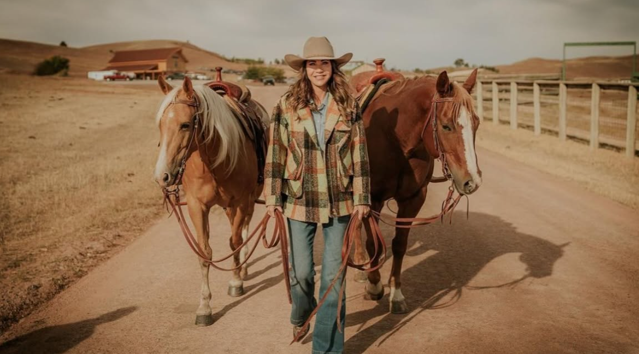 Horses are a recurring part of the rural scenes Kristi Noem has shared from South Dakota. Here, saddled horses stand along a road surrounded by fencing, dry grass, and open country. | Source: Facebook/kristi.noem