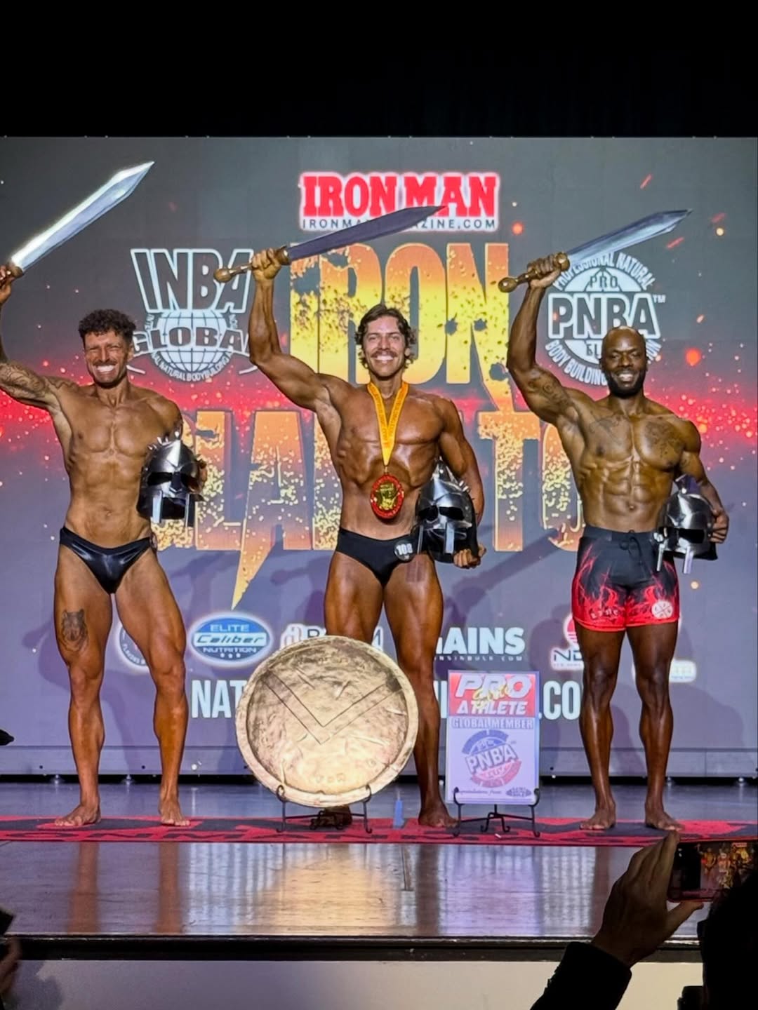 Joseph Baena celebrates alongside fellow competitors, lifting a sword while holding his award helmet after the final results. | Source: Instagram/joebaena