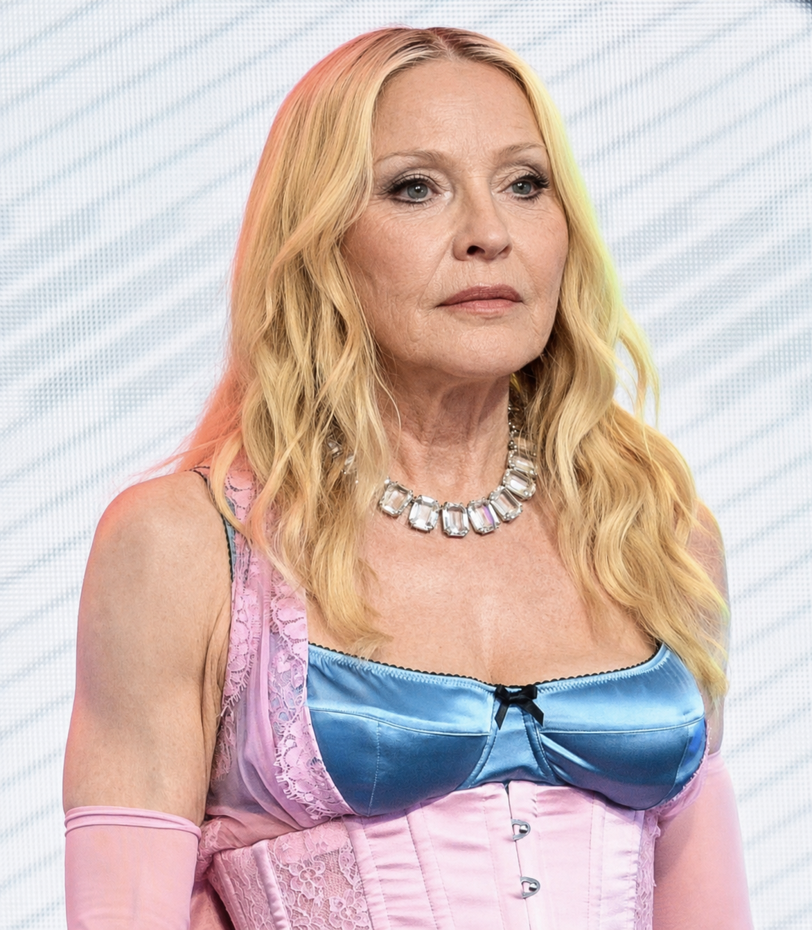 In the digitally transformed image, Madonna's colorful outfit and blond hairstyle remain while her face, neck and upper chest are presented with more visible signs of aging. | Source: Chat GPT