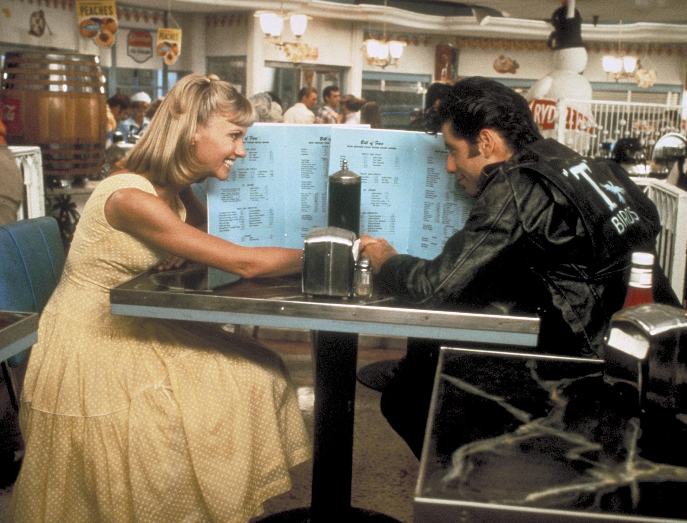 Sandy and Danny sharing a love-filled moment at a diner. | Source: Getty Images
