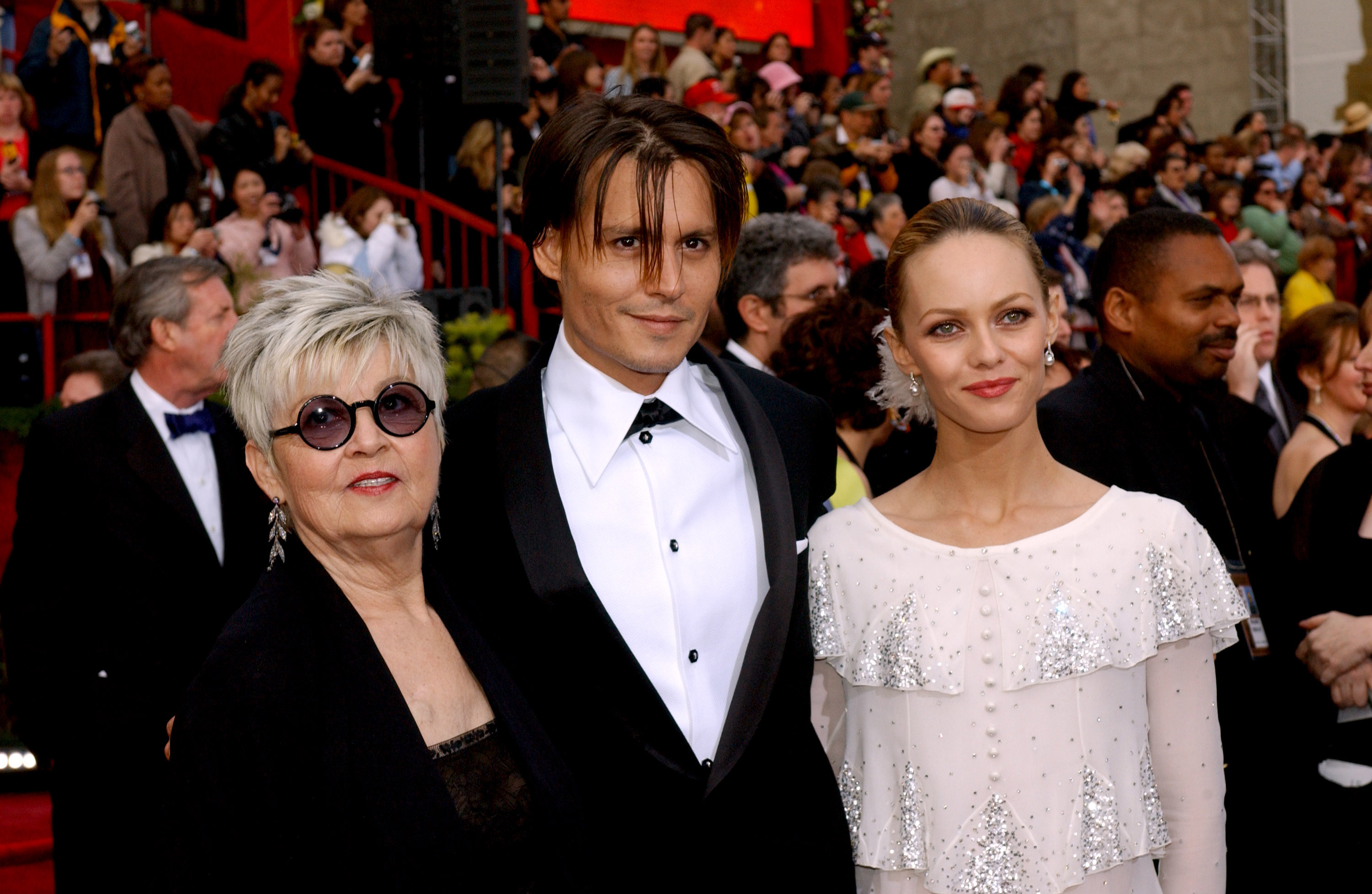 Johnny Depp poses on the Oscars red carpet alongside Vanessa Paradis and his mother Betty Sue Palmer | Source: Getty Images