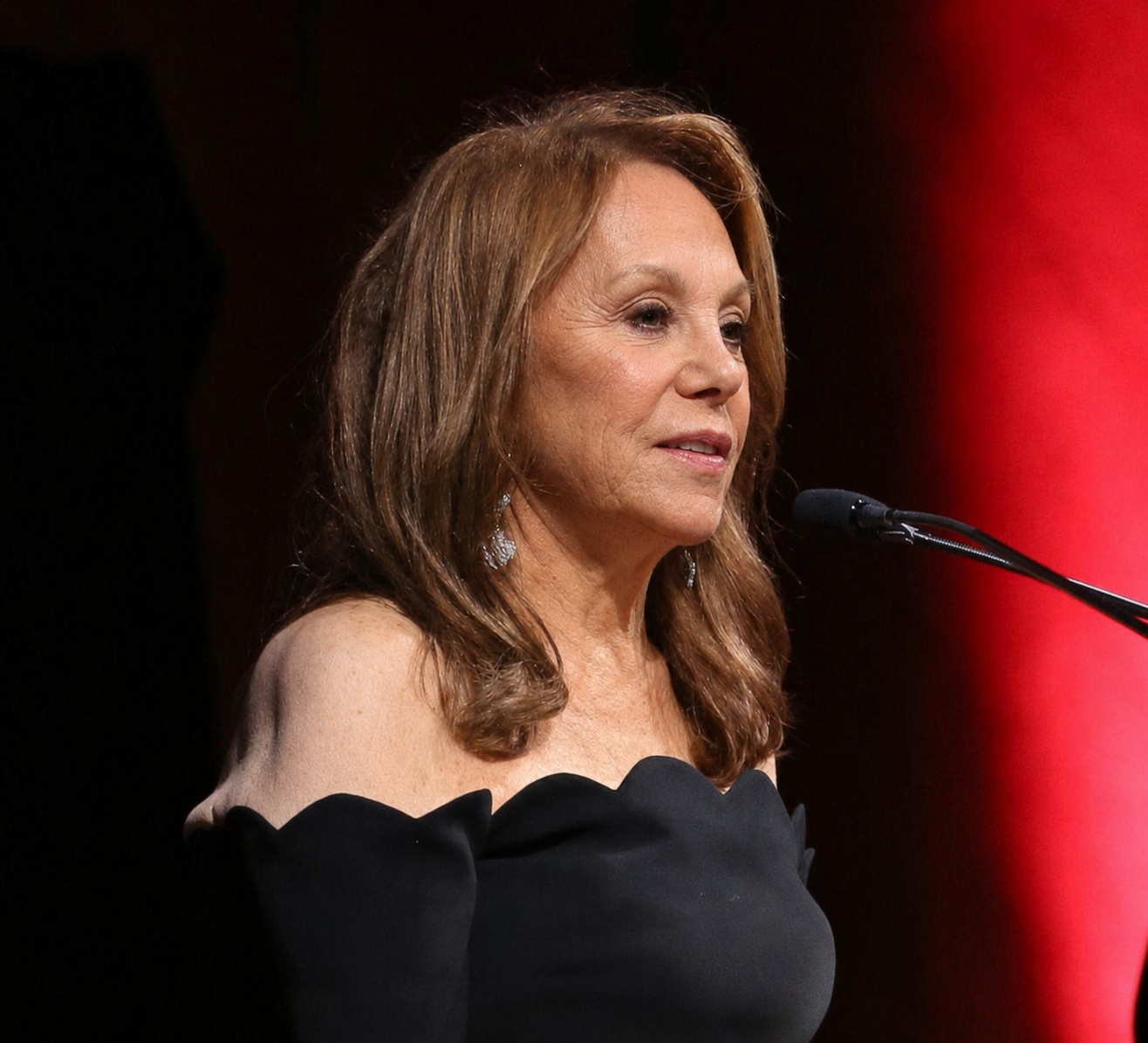 Marlo Thomas speaks at an event in an AI-generated image featuring an off-the-shoulder black gown. | Source: ChatGPT