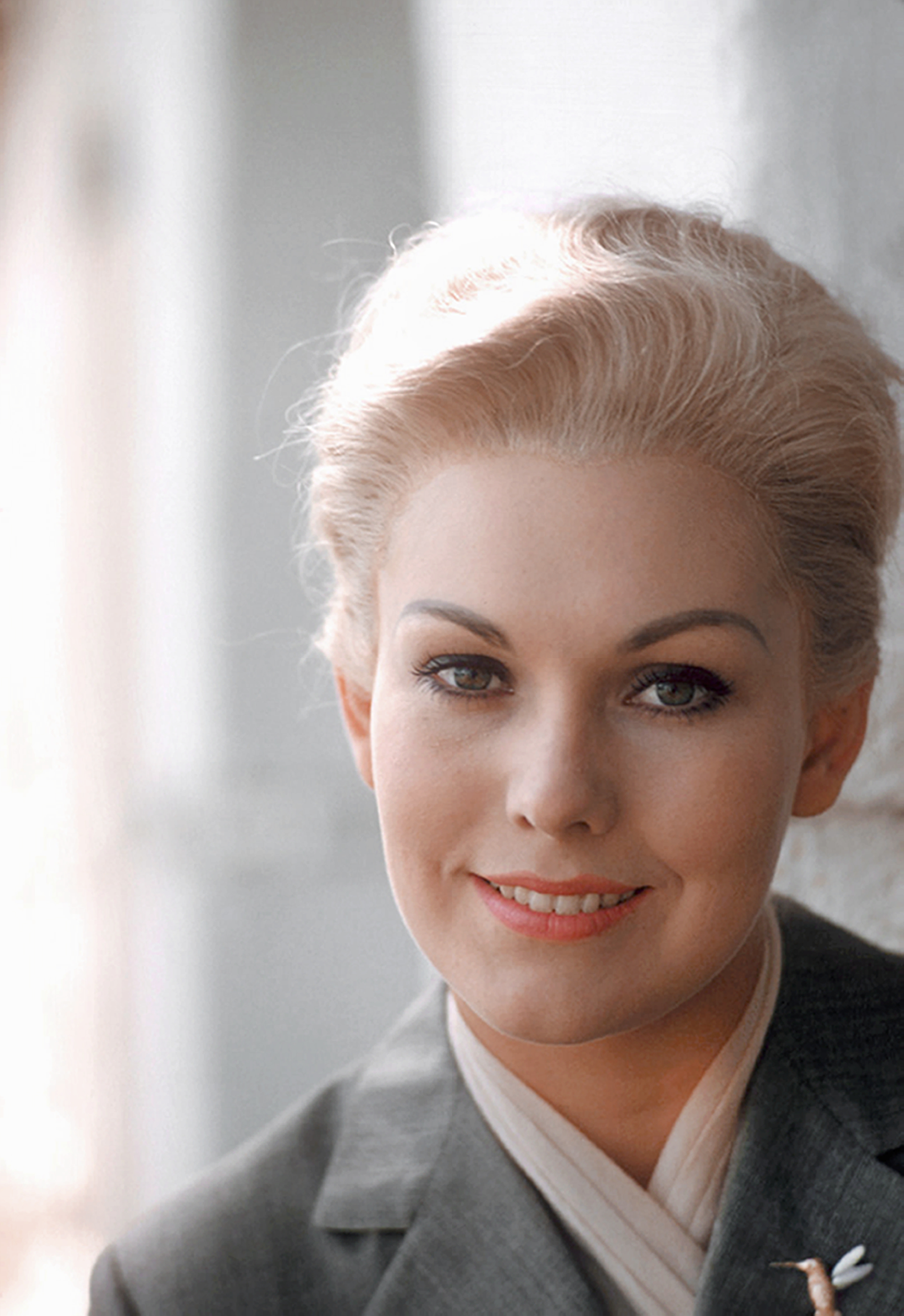 Kim Novak smiles in a close-up portrait taken during a session on the set of Vertigo, wearing a dark jacket over a light-colored top. | Source: Getty Images