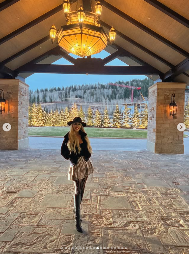 Jennifer Eckhart poses outdoors at a mountain resort, wearing a black hat, sweater, patterned skirt and knee-high boots against a snowy landscape. | Source: Instagram/jennifereckhart