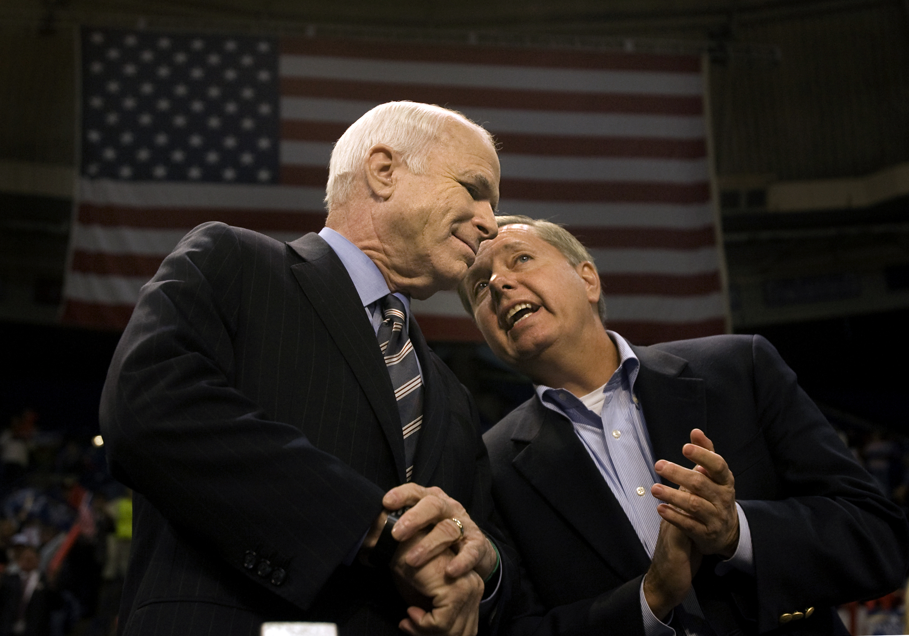 Lindsey Graham leans in to share a private remark with Sen. John McCain moments before a campaign rally begins. Their close working relationship would become one of the defining political partnerships of Graham's career. | Source: Getty Images