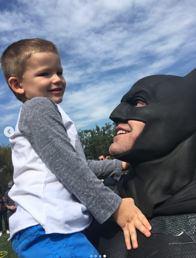 Ben Affleck, dressed in his Batman costume, shares a playful moment with his young son during an outdoor gathering. Fans were touched to see the throwback image included among Jennifer Garner's Father's Day memories, with many praising the former couple's enduring co-parenting relationship. | Source: Instagram/jennifer.garner