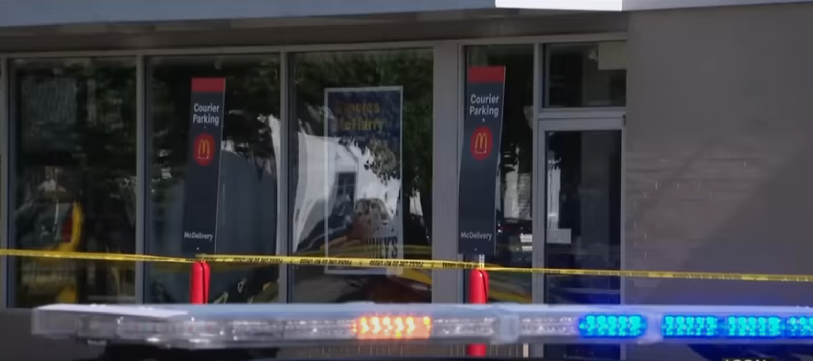 McDonald's in Eastpointe, Michigan, cordoned off by police following the death of Jennifer Harris, with a police siren in the foreground. From a video dated July 10, 2025. | Source: YouTube/ClickOnDetroitLocal4WDIV
