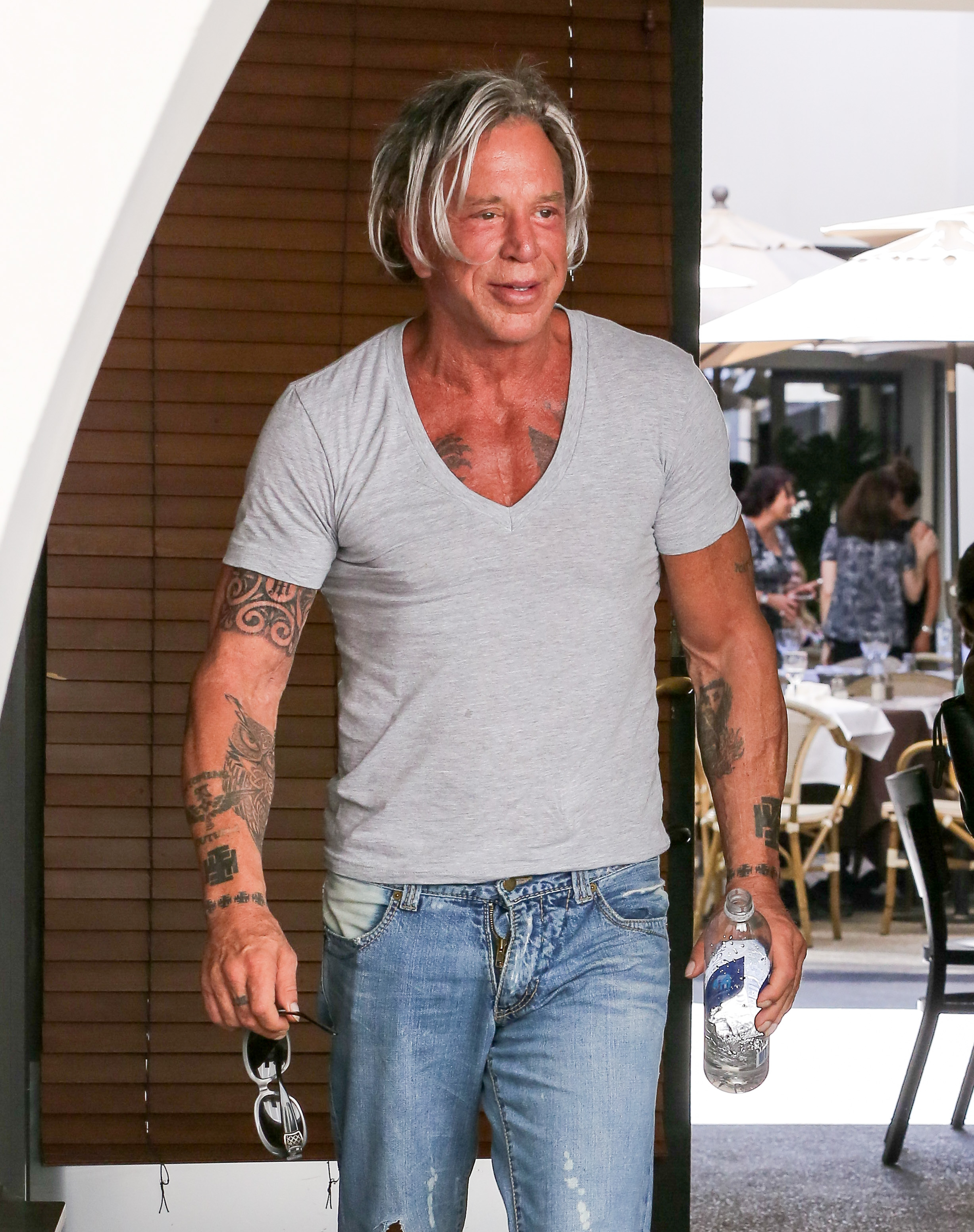 Mickey Rourke is spotted in Beverly Hills casually rocking a fitted grey tee and distressed jeans that show off his tattoos. With tousled silver-streaked hair and a bottle of water in hand, he exudes laid-back confidence and rugged charm.