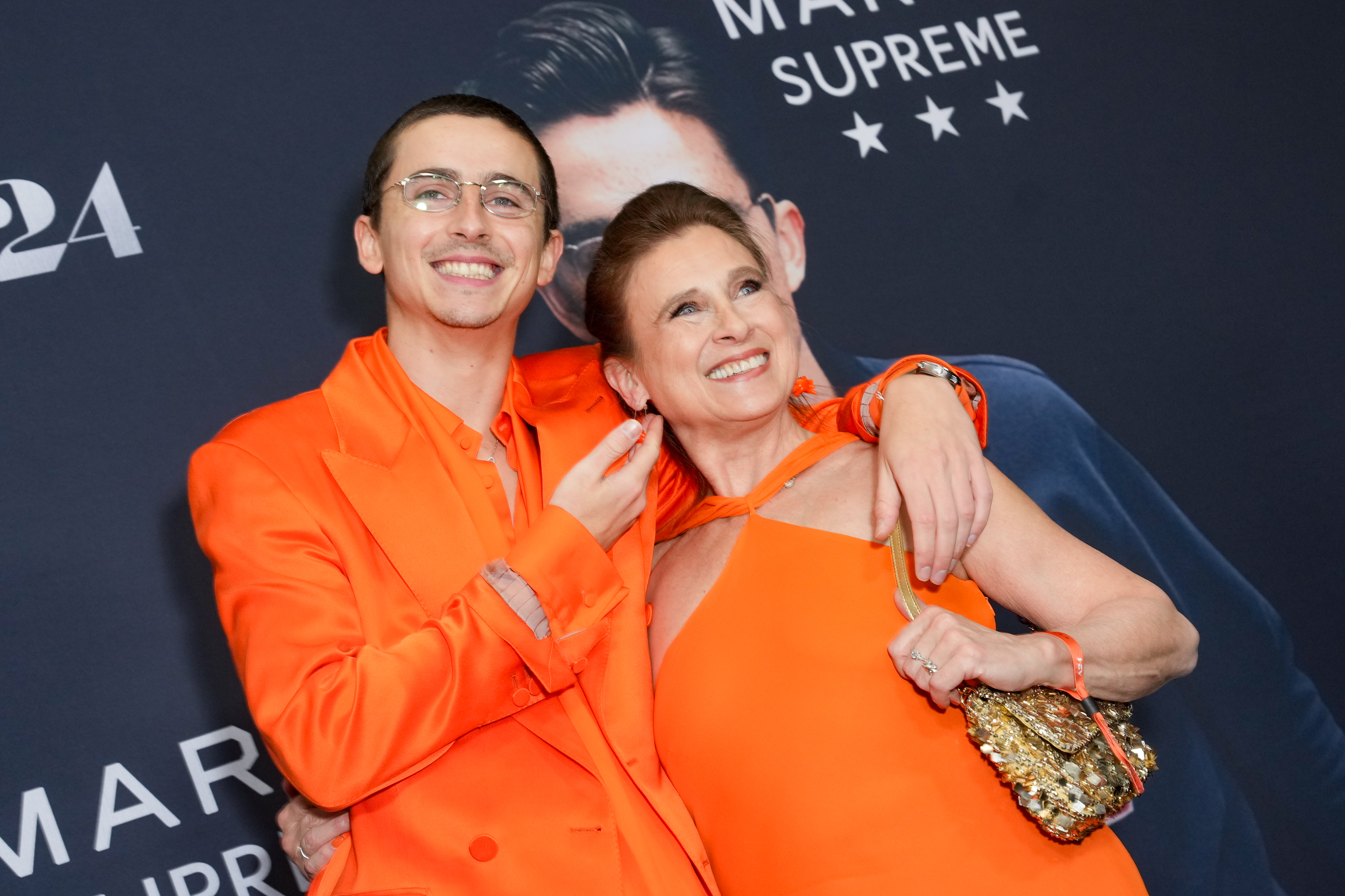 Timothée Chalamet smiling beside his mom, Nicole Flender-Chalamet, at the New York premiere. | Source: Getty Images