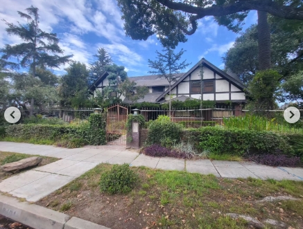 A wider street-level photograph shows more of the sprawling residence where Marvin Jr. died on April 1, 1984. The house stretches behind a long metal fence, with a gated walkway marking the entrance and thick shrubs lining the perimeter. Towering trees frame the property, while its peaked roof and contrasting timber accents remain clearly visible from across the sidewalk. | Source: Instagram/stephanosmoothlewis