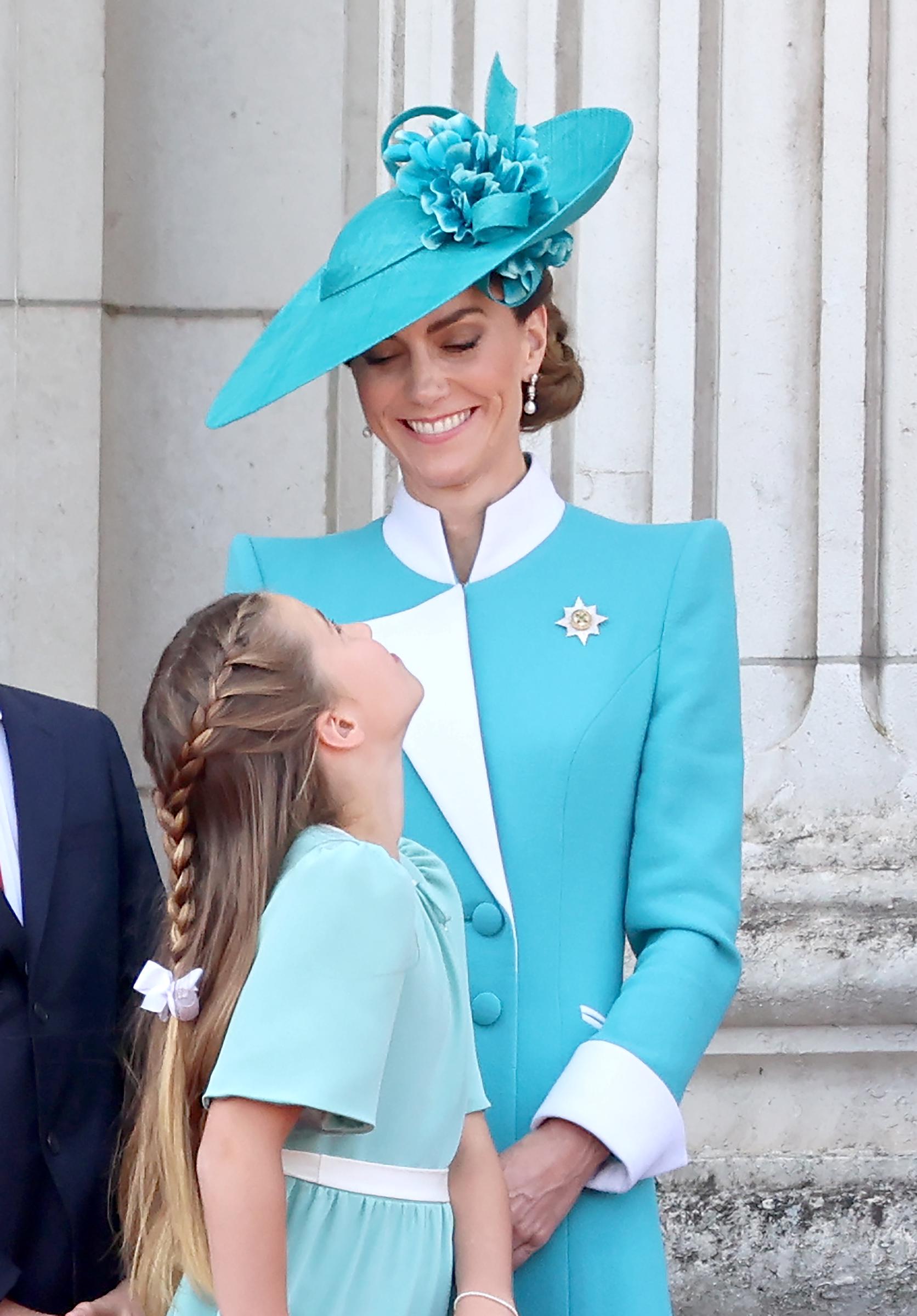 Princess Catherine shares a tender smile with Princess Charlotte as they stand together on the Buckingham Palace balcony during the 2025 Trooping the Colour. Charlotte gazes up at her mother, capturing a heartfelt exchange amid the formal ceremony that marks the monarch’s official birthday. The moment blends royal tradition with an intimate glimpse of family connection.