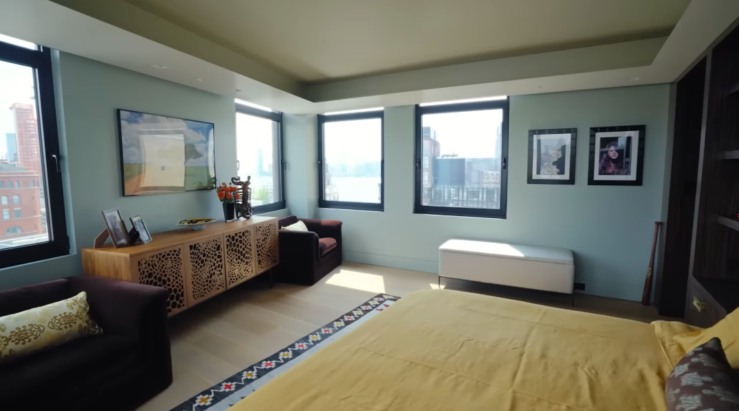 From the opposite side, the bedroom's generous proportions and wraparound windows become even clearer. Christopher said that despite the 270-degree outlook, the room still feels secure once the shades come down. | Source: YouTube/Architectural Digest