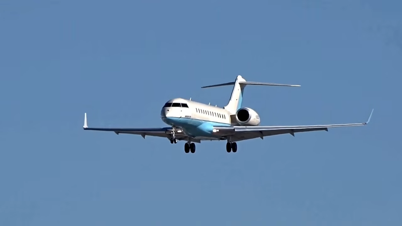 A Bombardier Global Express XRS aircraft makes its final descent with landing gear deployed against a clear blue sky. | Source: YouTube/@WorldOfLuxuryOfficial