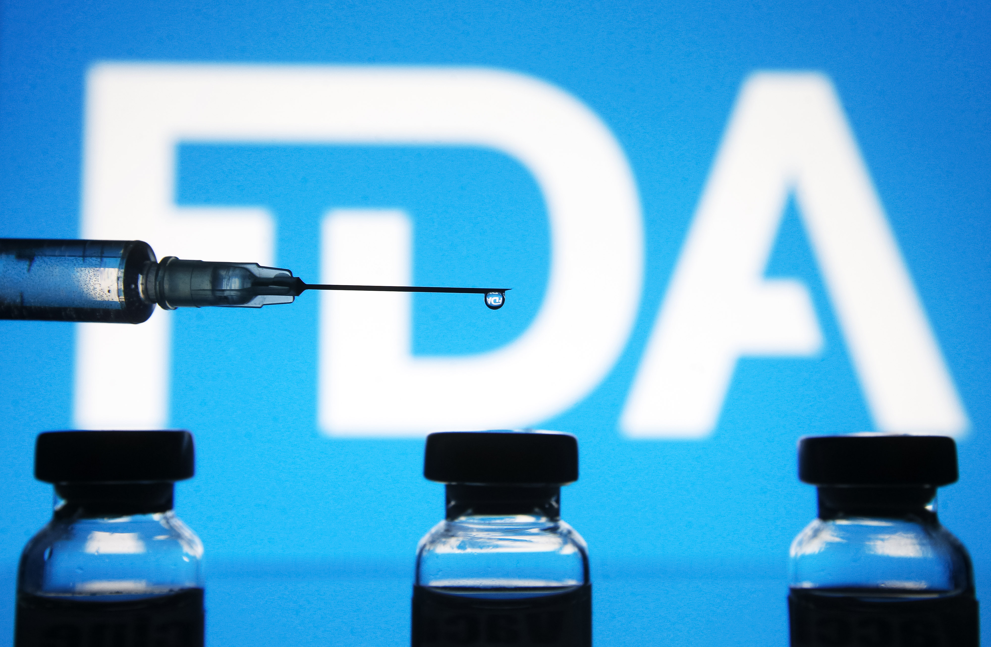 A photo of a medical syringe and vials in front of an FDA backdrop; photo taken in Ukraine on January 1, 2021. | Source: Getty Images