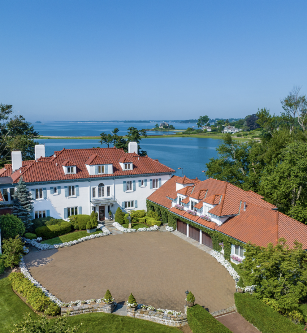 An aerial view of Kathie Lee Gifford's sprawling Connecticut estate reveals its Mediterranean-style architecture, red-tiled roofs, and grand circular driveway, with the waters of Long Island Sound stretching behind the property. | Source: Instagram/@sothebysrealty