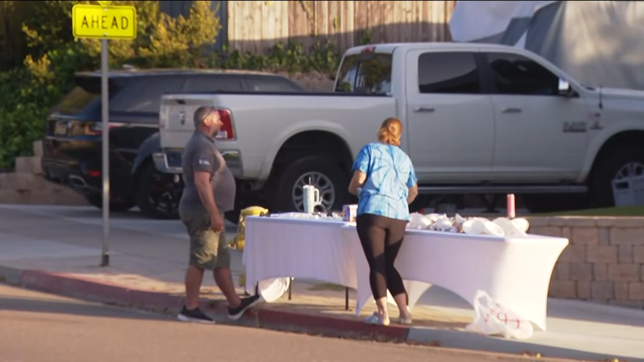 Neighbors prepare a table near the Voight family's home ahead of a candlelight vigil honoring Amy, David, and Mya. | Source: YouTube/FOX 5 San Diego