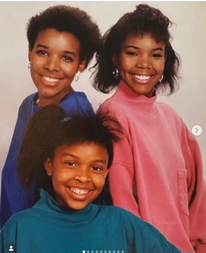 A young Gabrielle Union poses with two other girls in a studio portrait, all smiling brightly in colorful sweaters — blue, pink, and teal — styled in a classic, retro look. | Source: Instagram/gabunion