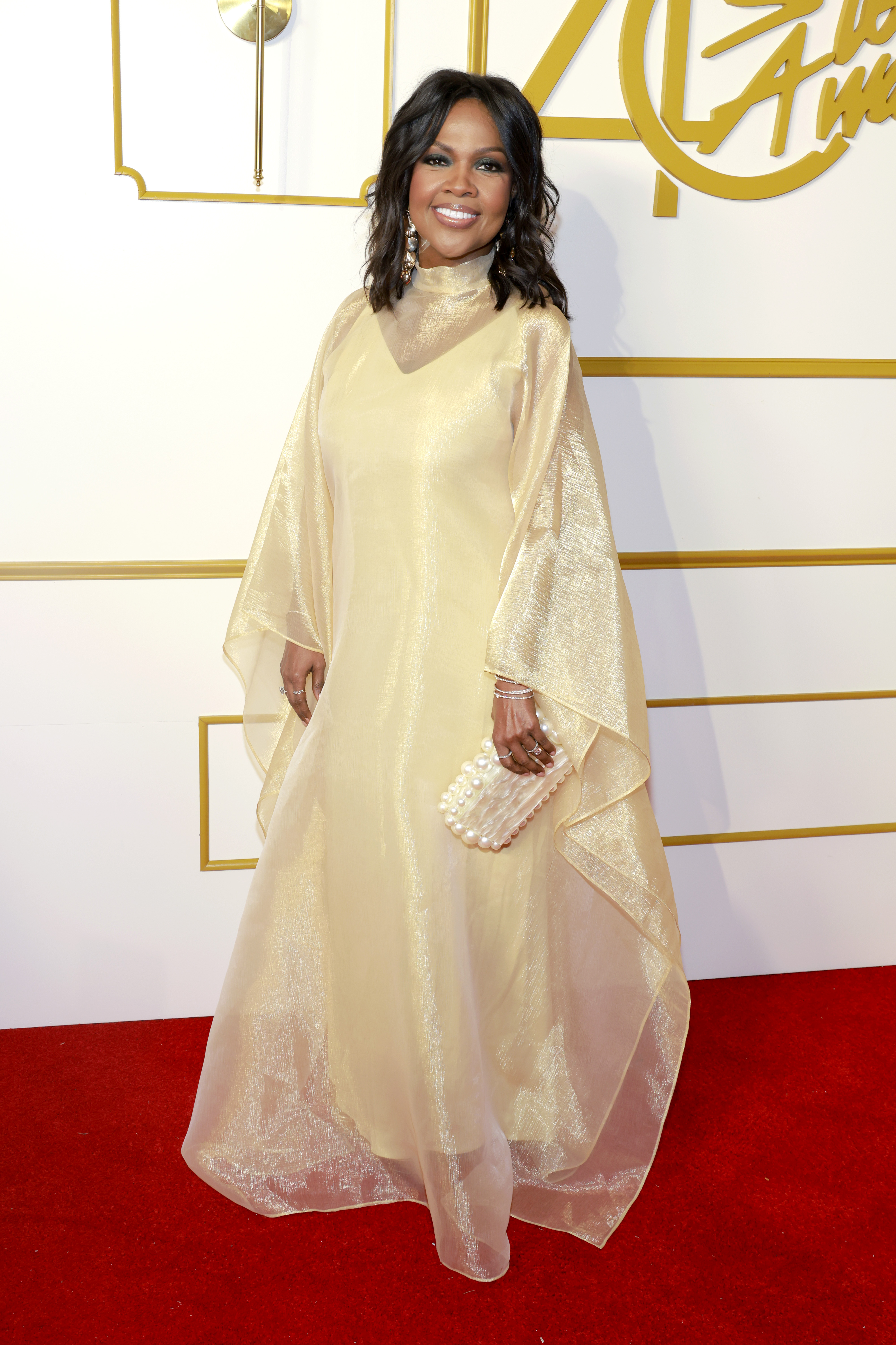 CeCe Winans stands on the red carpet while holding a pearl handbag during the 40th Annual Stellar Gospel Music Awards in Nashville, Tennessee.