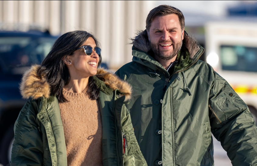 JD Vance and his wife, Usha, walk outdoors in daylight wearing heavy green winter jackets. Usha, in sunglasses and a tan sweater, looks toward JD with a smile, while JD smiles ahead. | Source: Instagram/vp