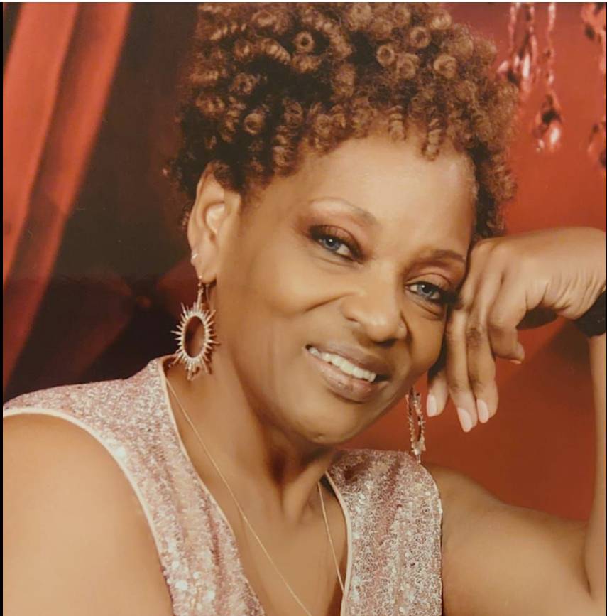 Deborah Tolson smiles gently at the camera, resting her head lightly on her right hand in a relaxed pose. | Source: Facebook/DeborahTolson