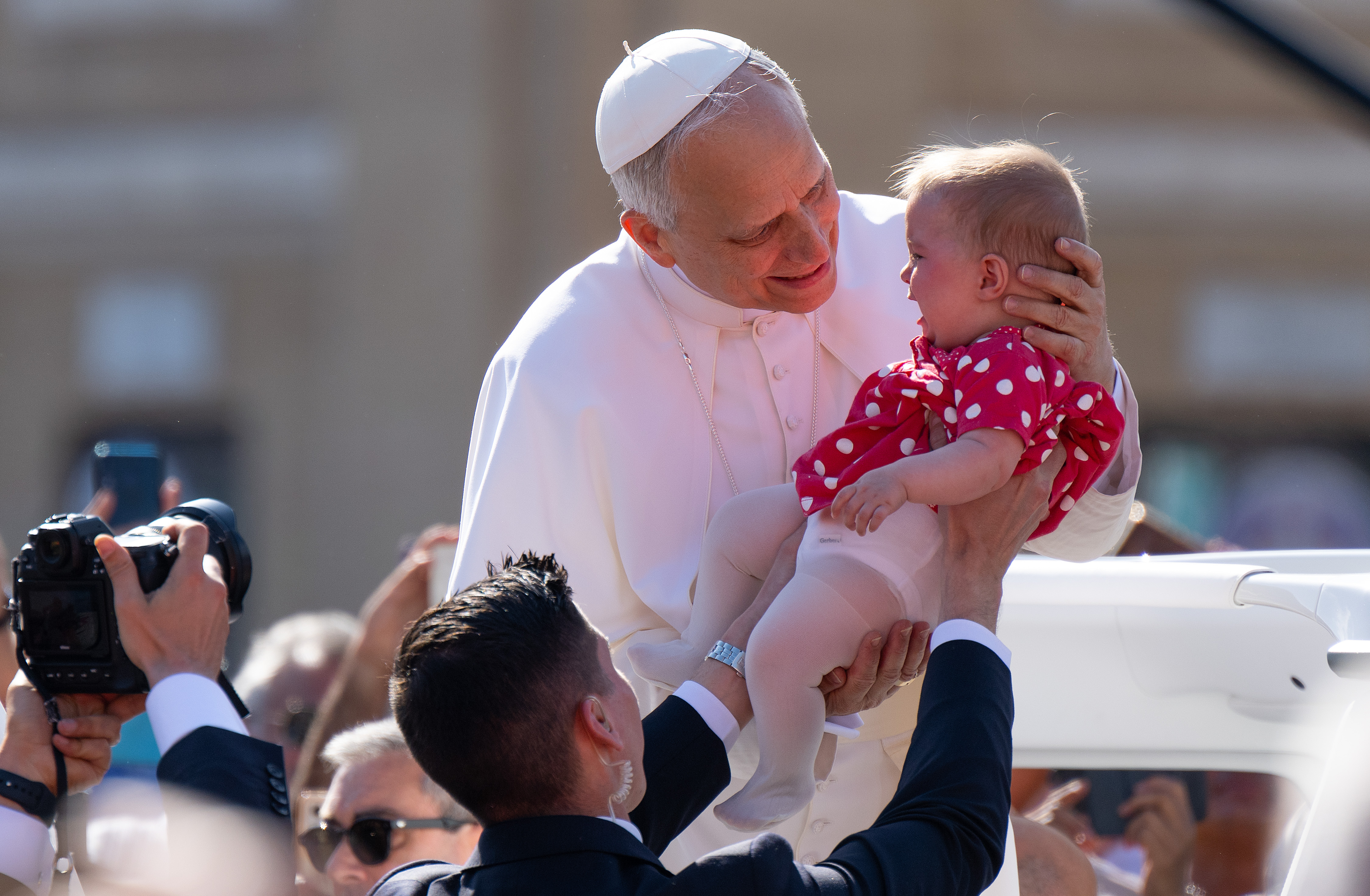 Pope Leo XIV holds a baby as he arrives ahead of the Inauguration Mass of Pope Leo XIV in St Peter's Square in Vatican City, on May 18, 2025 | Source: Getty Images