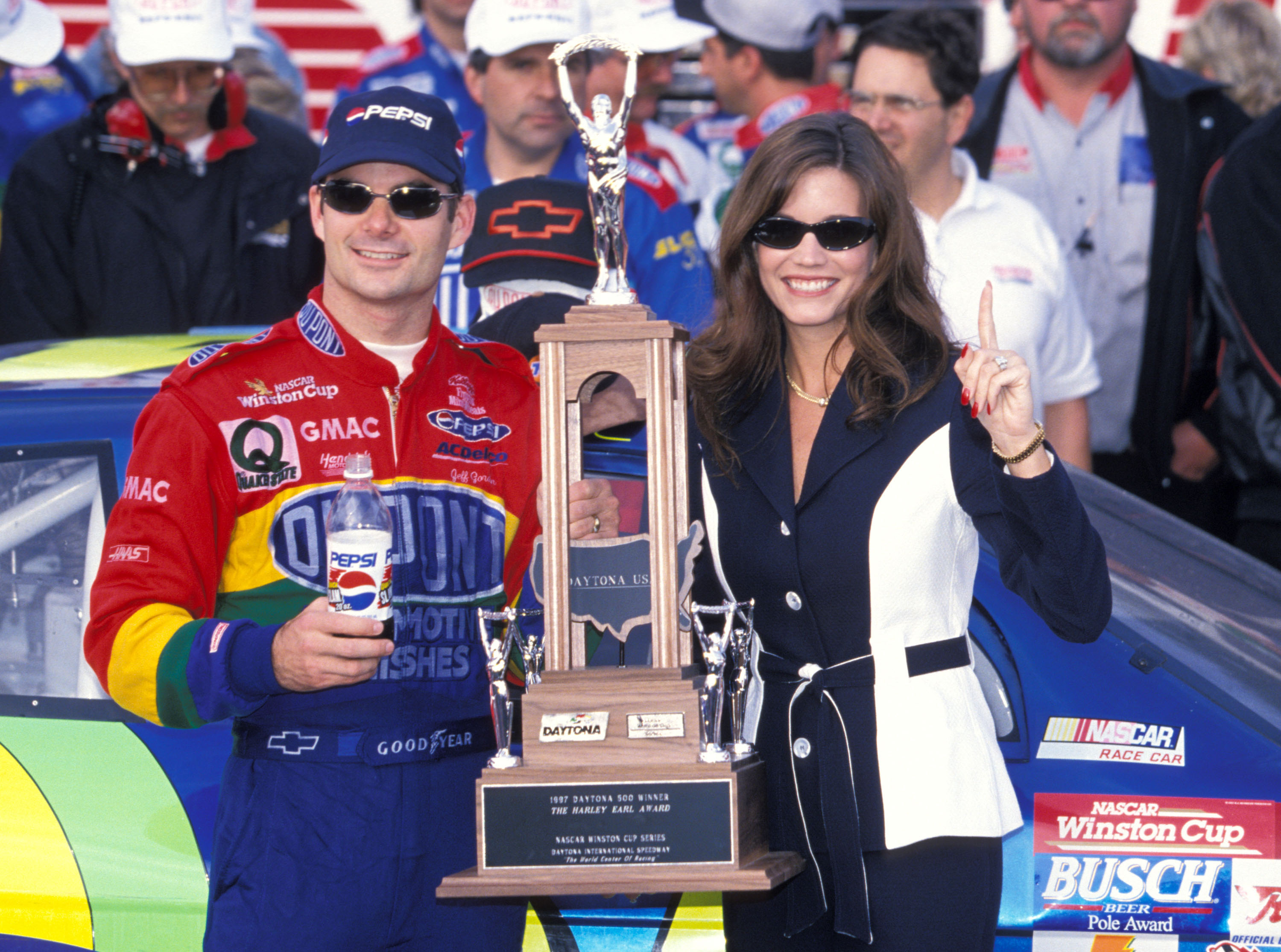 Jeff Gordon celebrated his Daytona 500 victory alongside his then-wife, Brooke Sealey, on December 2, 1997. Posing beside the winner's trophy, Gordon remained in his racing suit while Sealey held up one finger, capturing a celebratory moment from their marriage as his NASCAR career flourished.