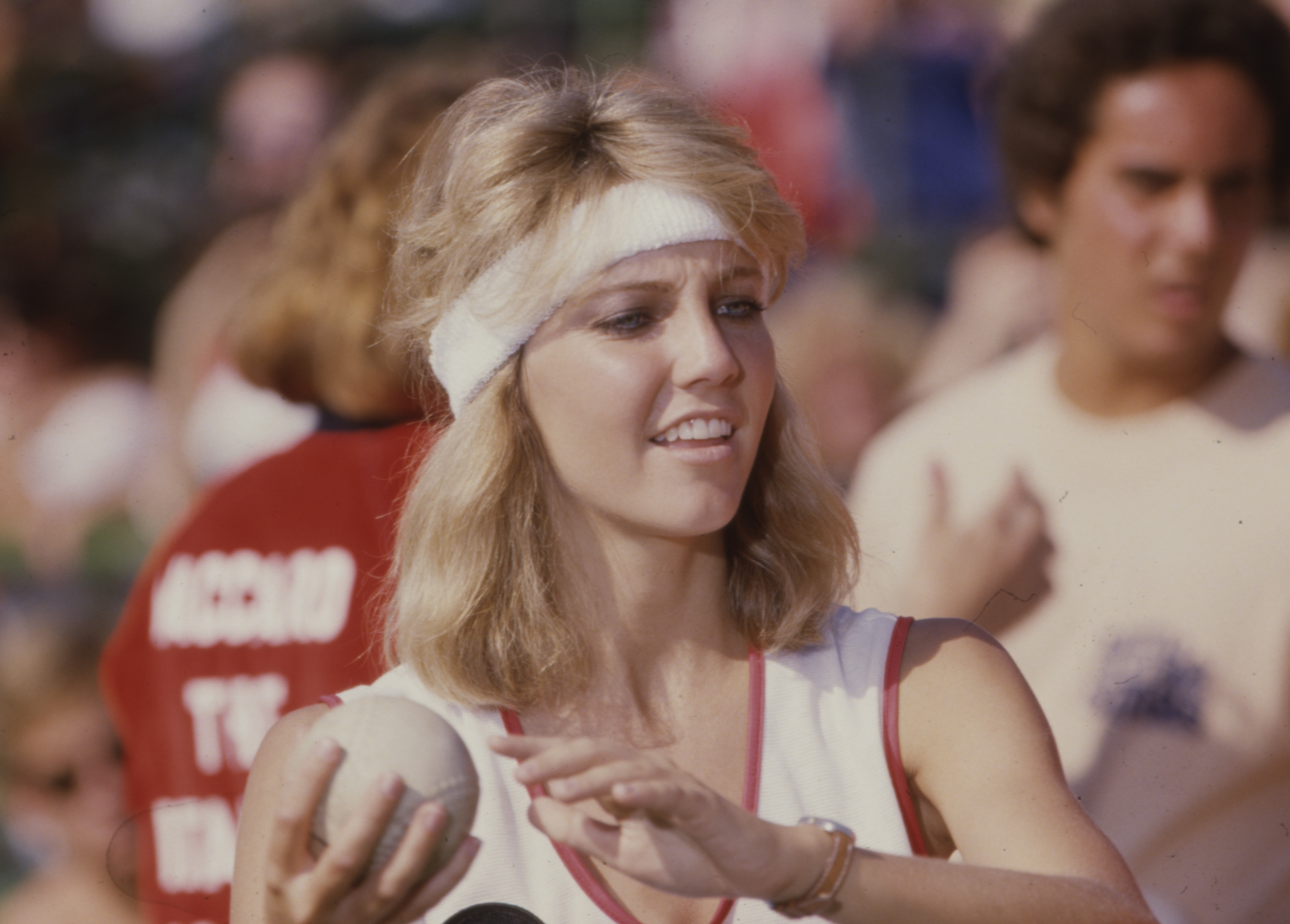 Heather Locklear gets into the competitive spirit during the ABC television special "Battle of the Network Stars IV" in Malibu, California, in 1978. Sporting feathered blonde locks pushed back with a white terrycloth sweatband, the actress prepares to throw a ball while wearing a white athletic tank top with red trim and a watch. | Source: Getty Images