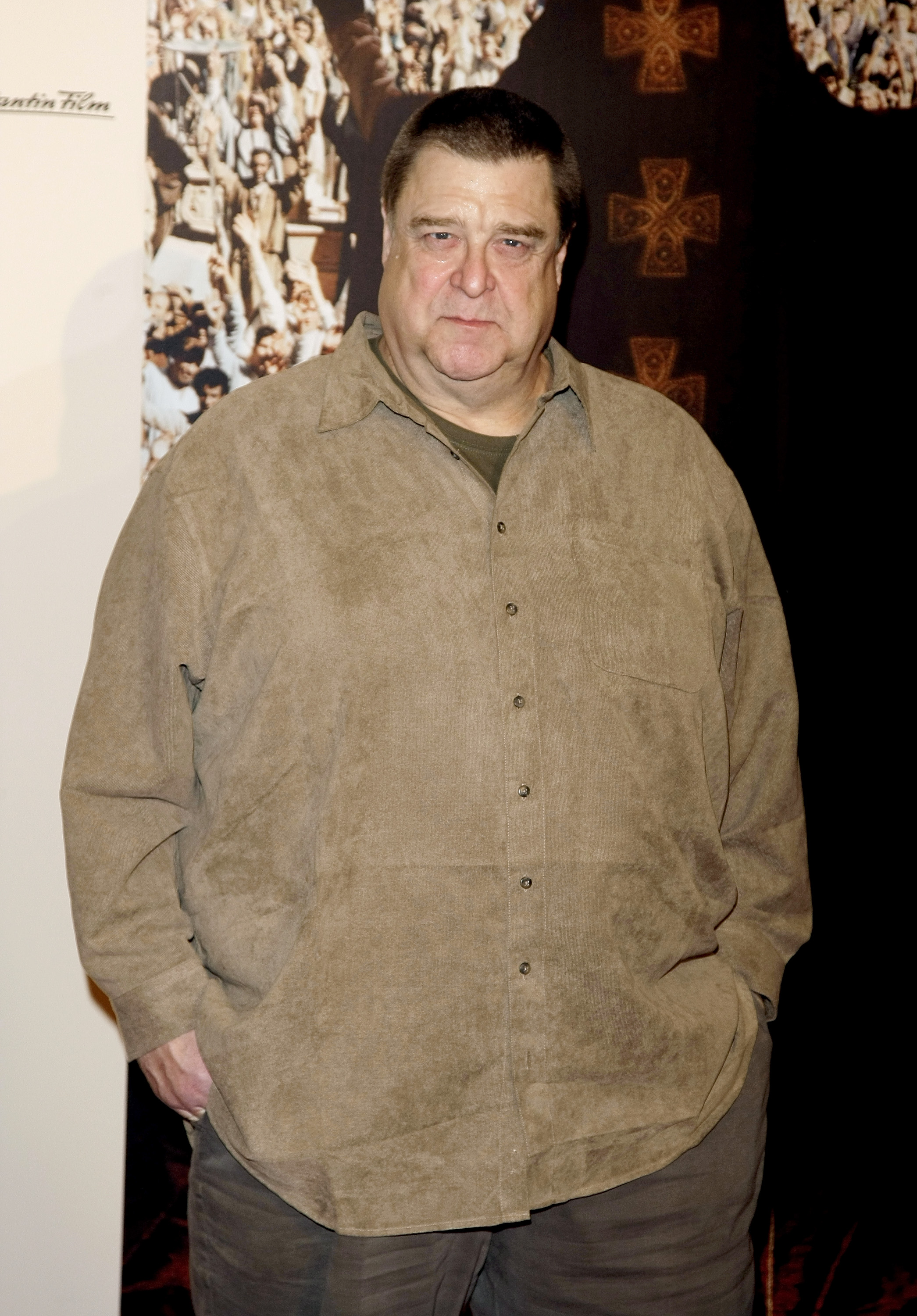 At a photocall for the same film, Goodman opted for a loose brown button-down shirt and dark pants. The closer view provides another look at his build during that period, helping establish the visual contrast with the transformation that became increasingly apparent in the years ahead.