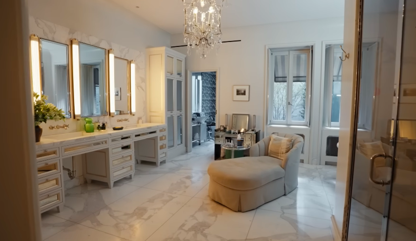 The bathroom is less a bathroom than a full Old Hollywood dressing salon. The chaise is the kind of detail only Kelly Ripa could explain with a Joan Crawford reference. | Source: YouTube/Architectural Digest