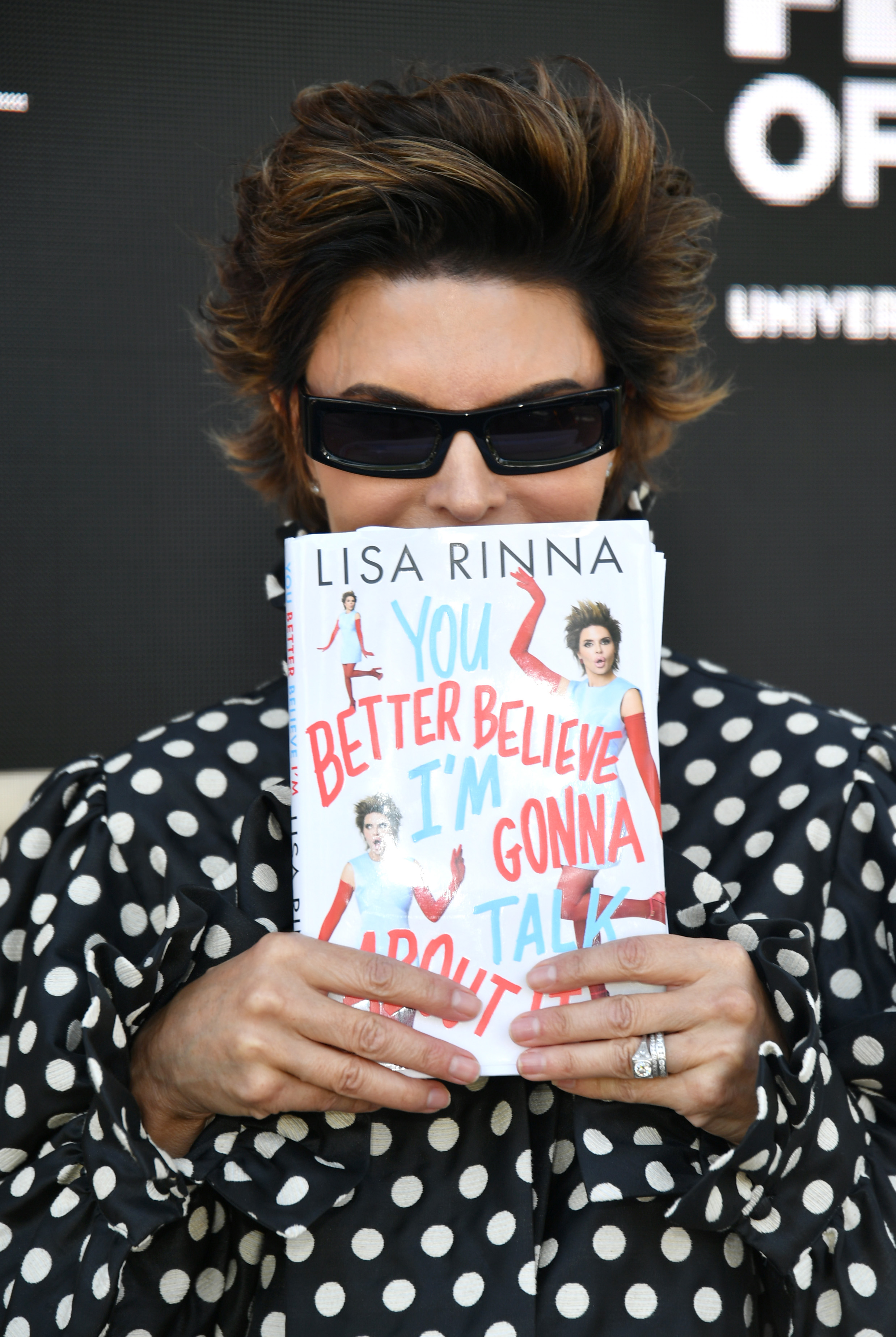 Lisa Rinna posed with her memoir, "You Better Believe I'm Gonna Talk About It," at the Los Angeles Times Festival of Books on April 18, 2026. In the book, she opened up about her difficult working relationship with former "Days of Our Lives" co-star Robert Kelker-Kelly. | Source: Getty Images