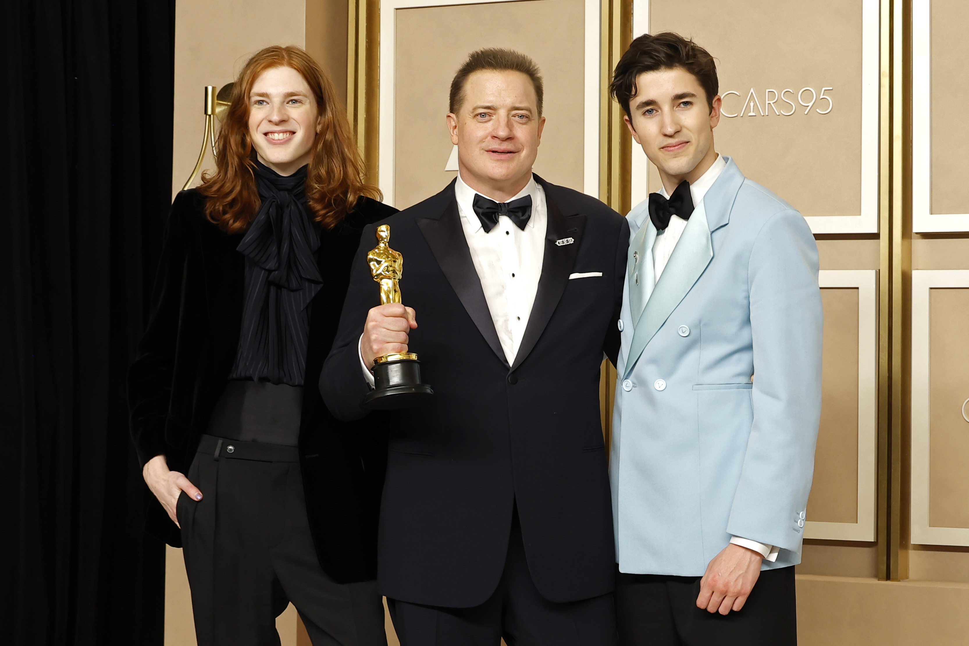 Leland Fraser stood beside his father, Brendan Fraser, and older brother Holden Fraser in the press room at the 95th Annual Academy Awards in Hollywood, California. Brendan proudly held up his Best Actor Oscar for "The Whale," while Leland, then 16, smiled in an all-black ensemble with his long red hair worn loose. Holden completed the family portrait in a light blue tuxedo jacket as the brothers celebrated their father's career milestone on March 12, 2023.